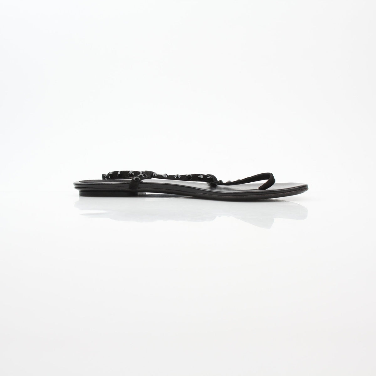 Gucci black crystal-embellished T-strap flat sandals with gold accents, showcasing elegant footwear design and intricate detailing.
