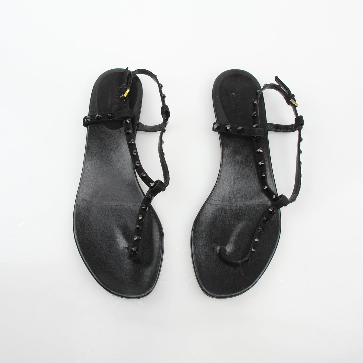 Gucci black crystal-embellished T-strap flat sandals with elegant design, showcasing crystal accents and sleek black leather straps.