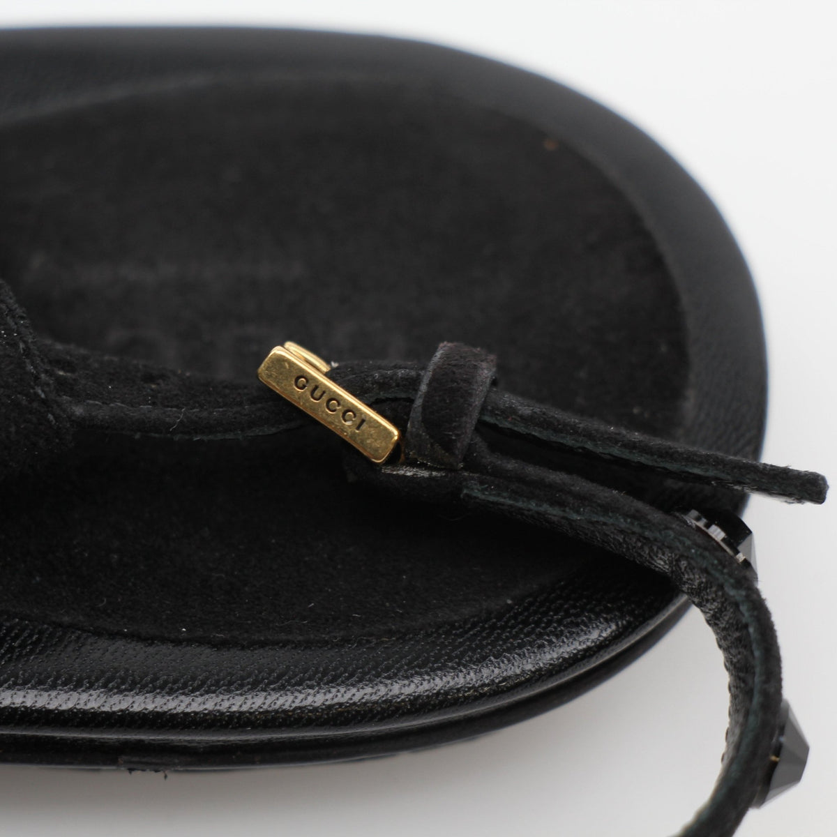 Gucci black crystal-embellished T-strap flat sandals with sleek design and elegant detailing, showcased on a neutral background.