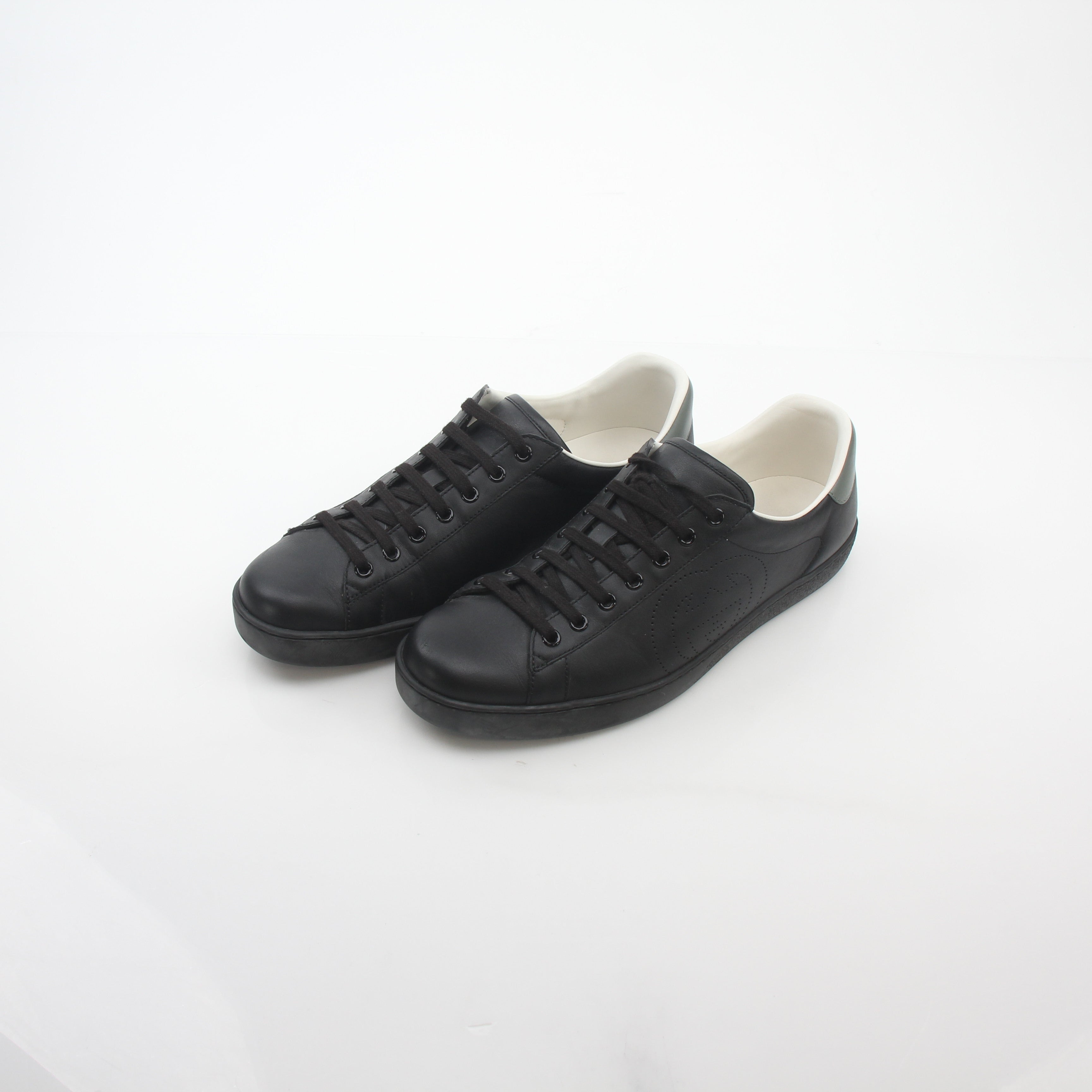 Gucci black leather Brooklyn low-top sneakers with white sole and gold accents, casual shoe style for men.