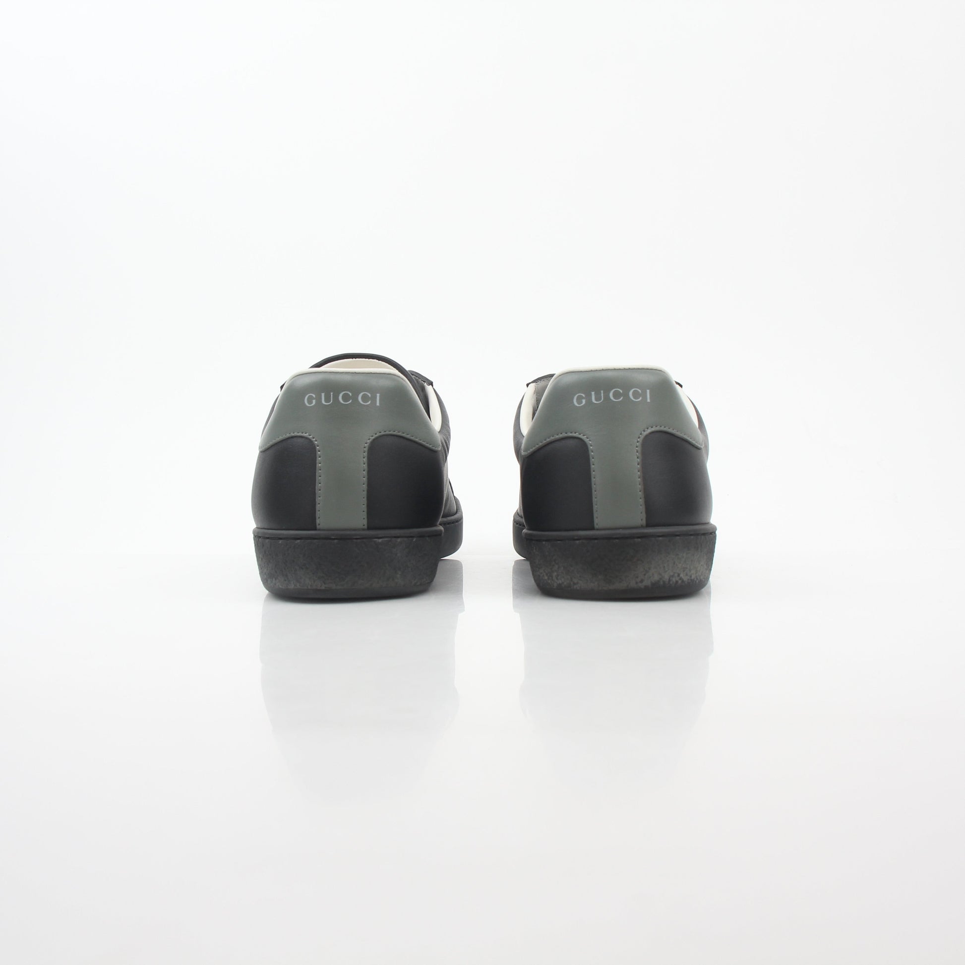 Gucci black leather Brooklyn low-top sneakers with white rubber soles and Gucci logo detail, stylish shoes for casual wear.