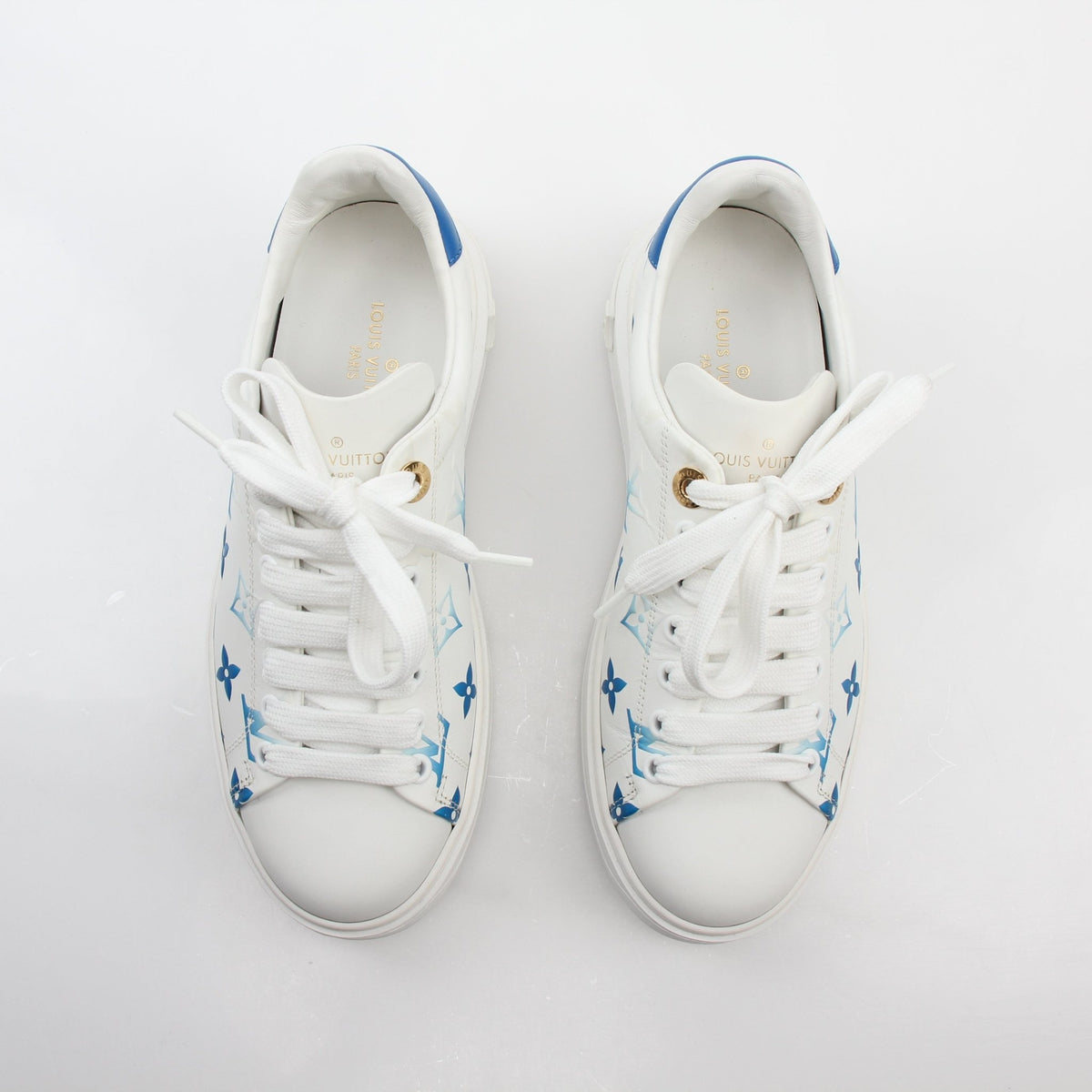 Louis Vuitton white and blue Monogram Time Out sneakers, stylish shoes by Gold & Beyond with distinctive monogram design.