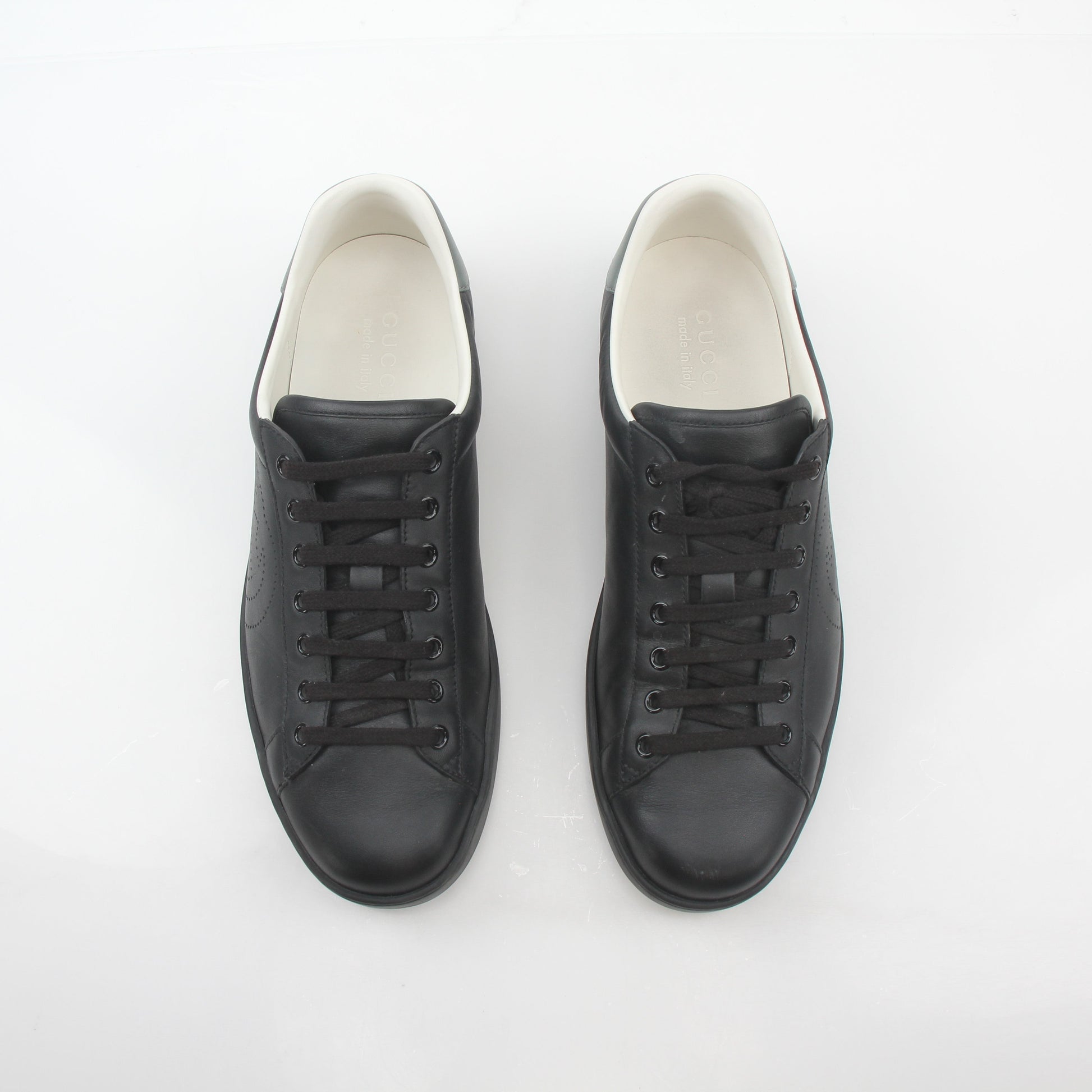 Gucci black leather Brooklyn low-top sneakers with gold accents, casual shoes for men and women, stylish and comfortable footwear.