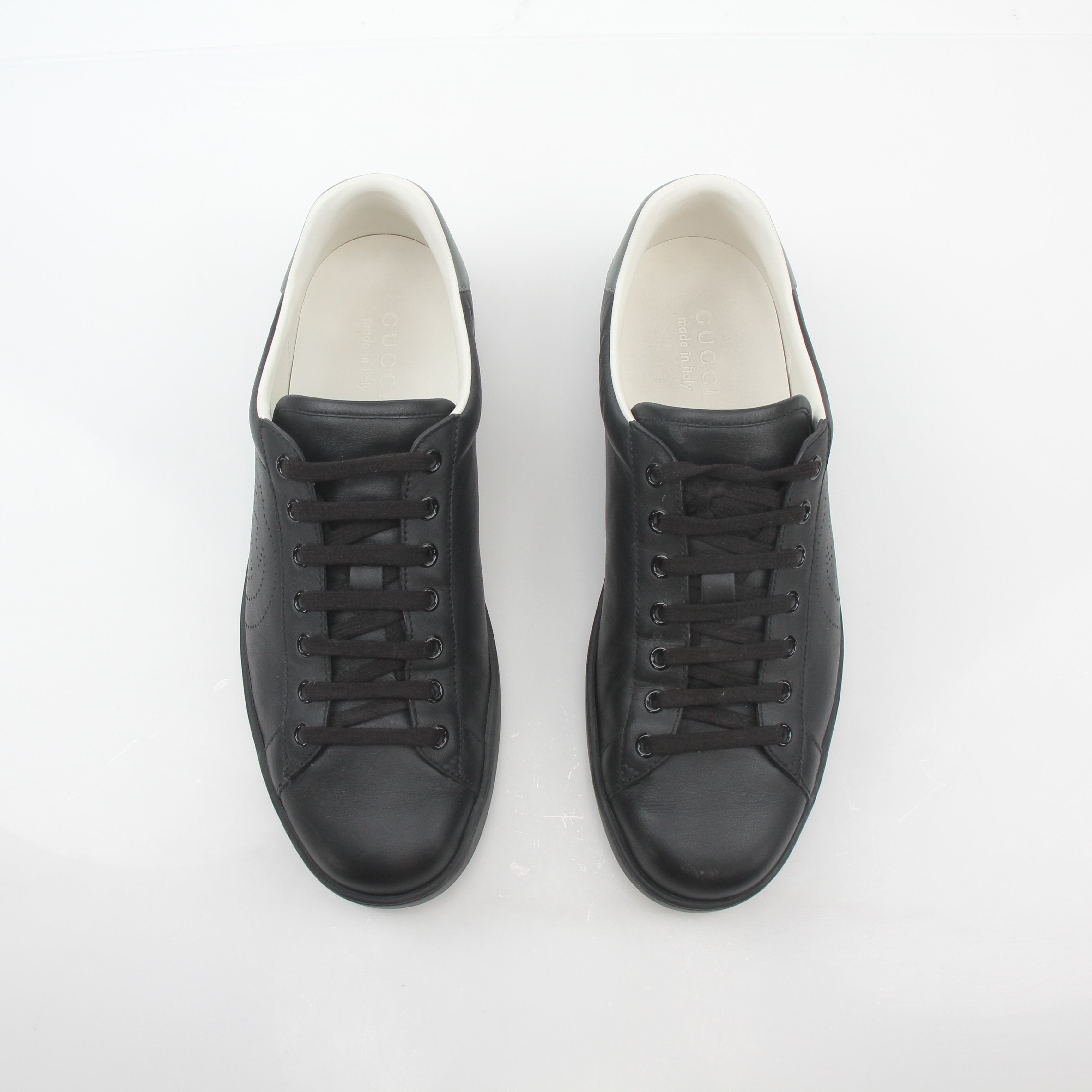 Gucci black leather Brooklyn low-top sneakers with gold accents, casual shoes for men and women, stylish and comfortable footwear.