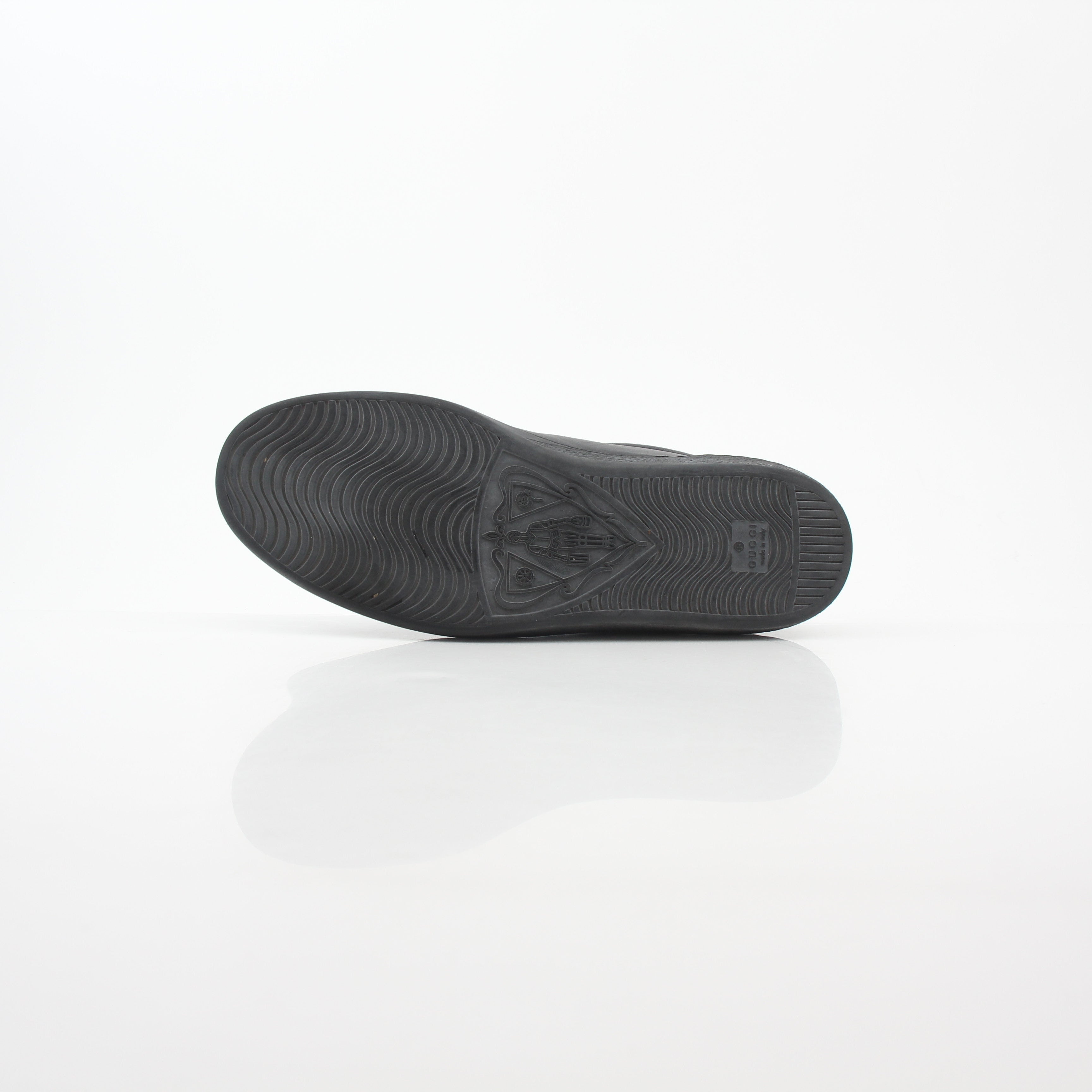 Gucci black leather Brooklyn low-top sneakers with gold accents and classic design, displayed on a plain background.