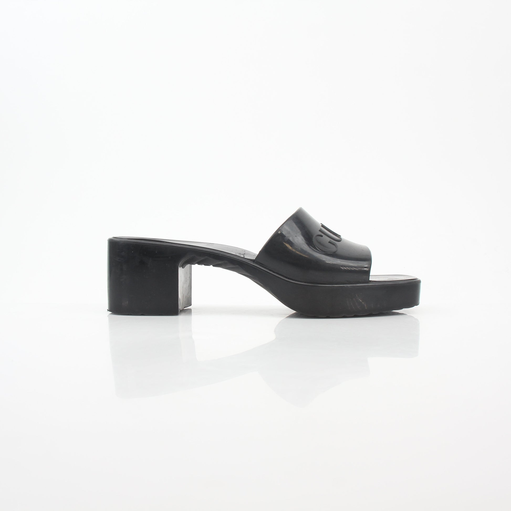 Gucci black rubber logo platform slide sandals, casual open-toe shoes with thick soles and Gucci branding visible.