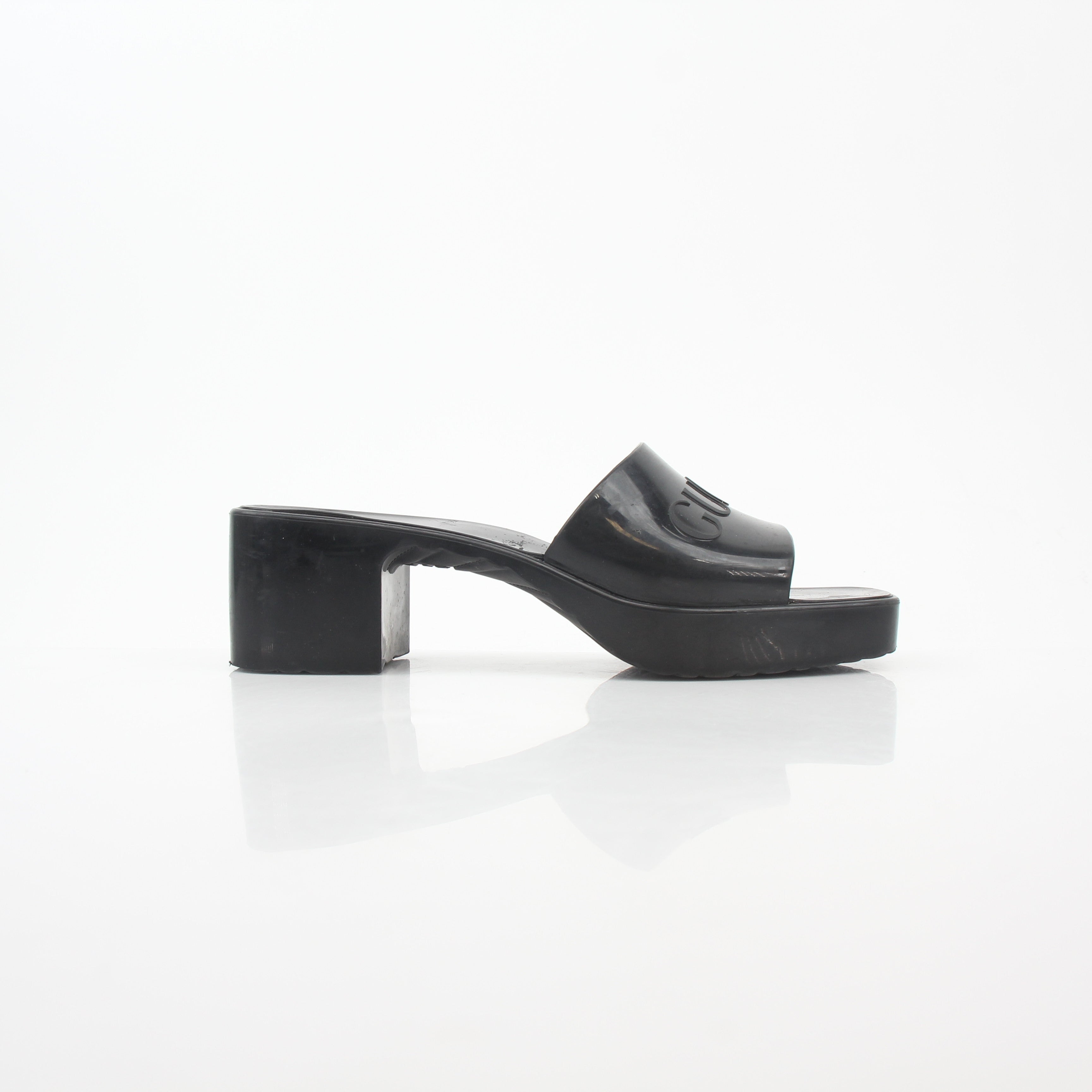 Gucci black rubber logo platform slide sandals, casual open-toe shoes with thick soles and Gucci branding visible.