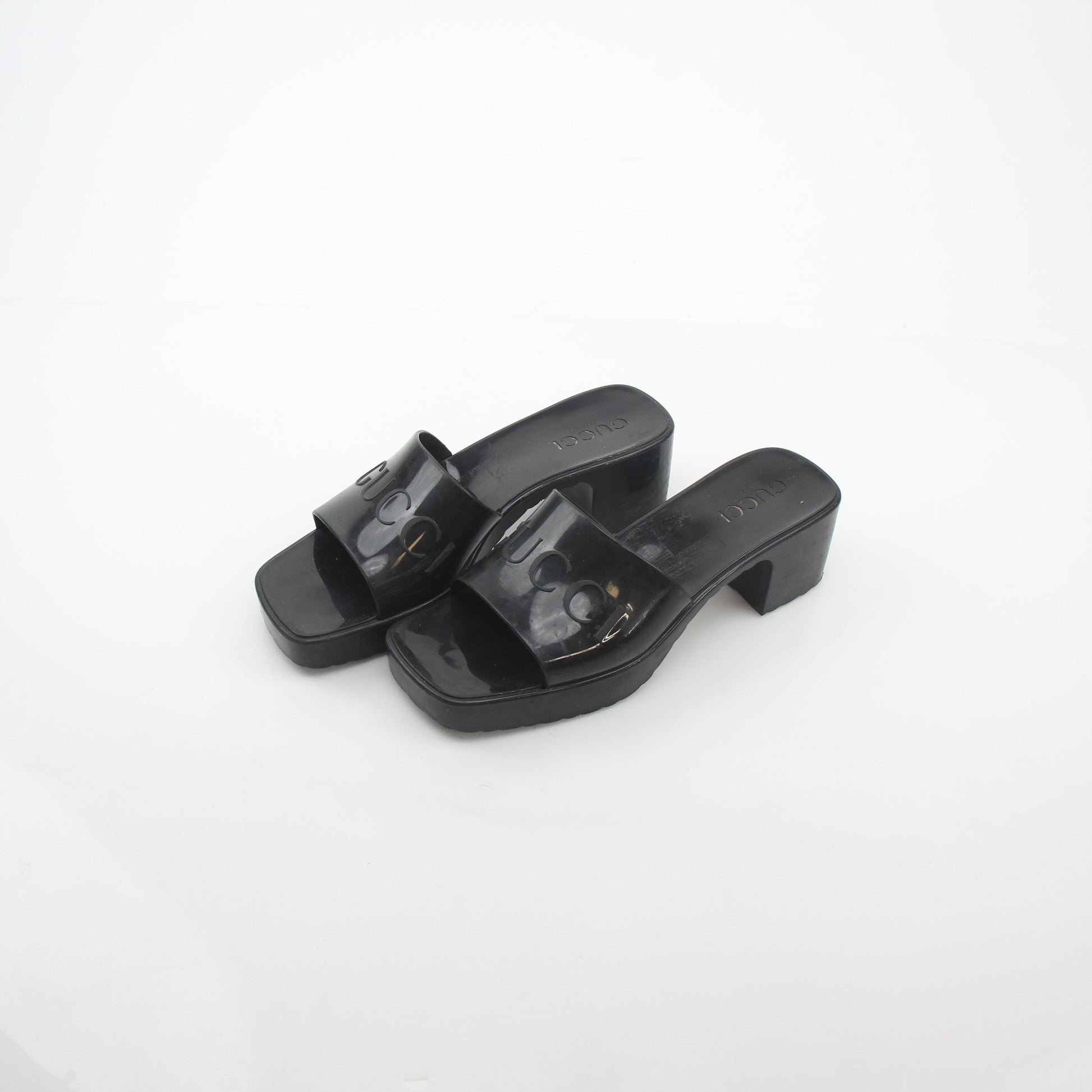 Gucci black rubber logo platform slide sandals with thick sole and wide strap featuring Gucci logo branding.