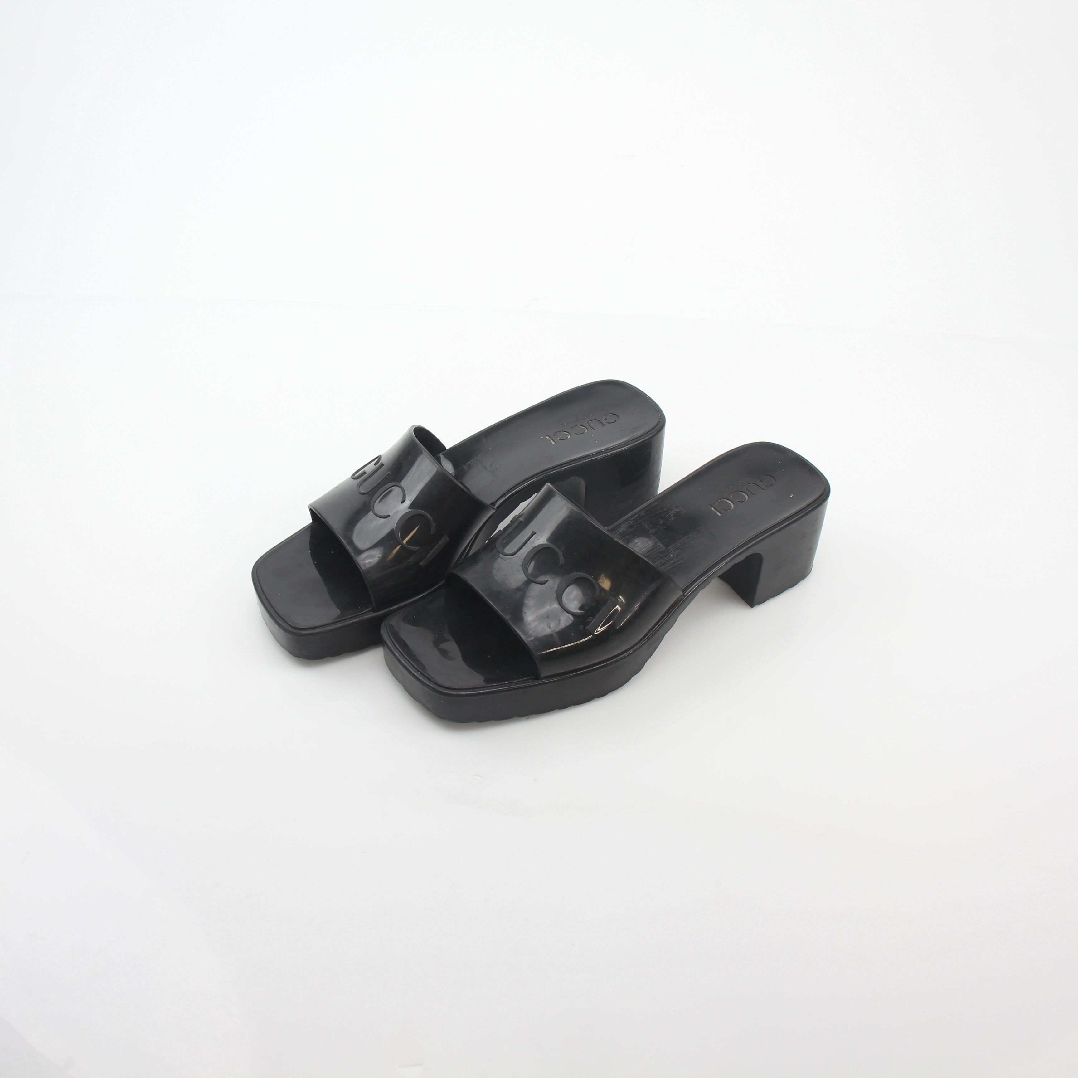 Gucci black rubber logo platform slide sandals with thick sole and wide strap featuring Gucci logo branding.