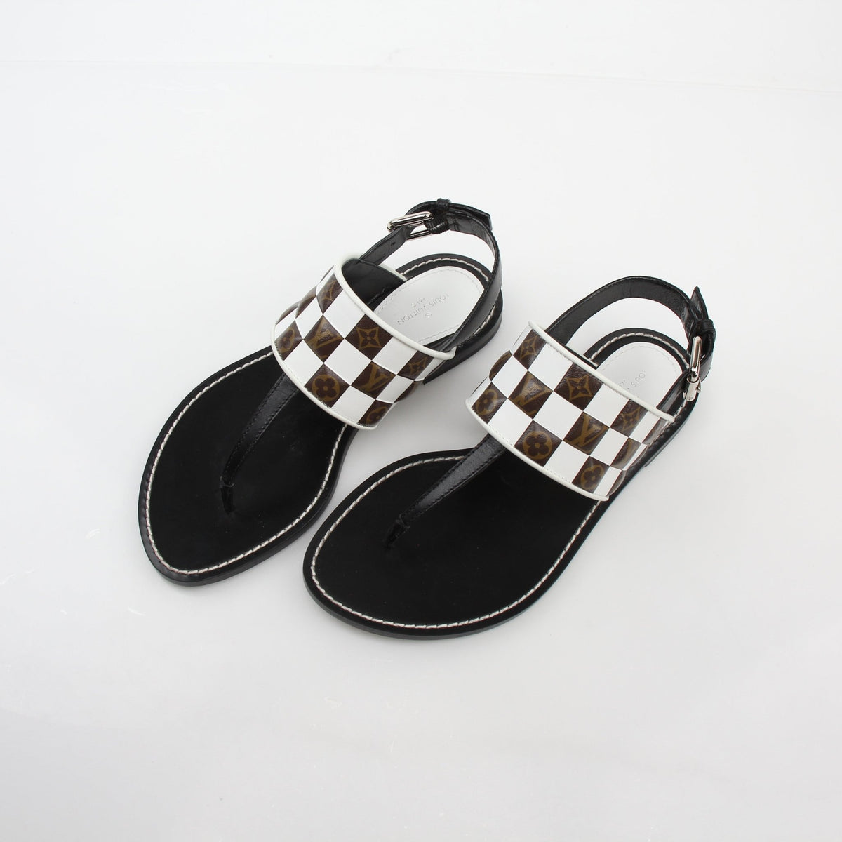 Louis Vuitton black and white monogram matchmake flat thong sandals with gold accents, casual shoe style from Gold & Beyond.