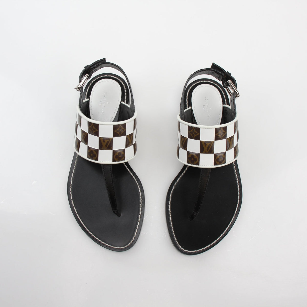 Louis Vuitton black and white monogram matchmake flat thong sandals with gold accents, stylish shoes for warm weather.