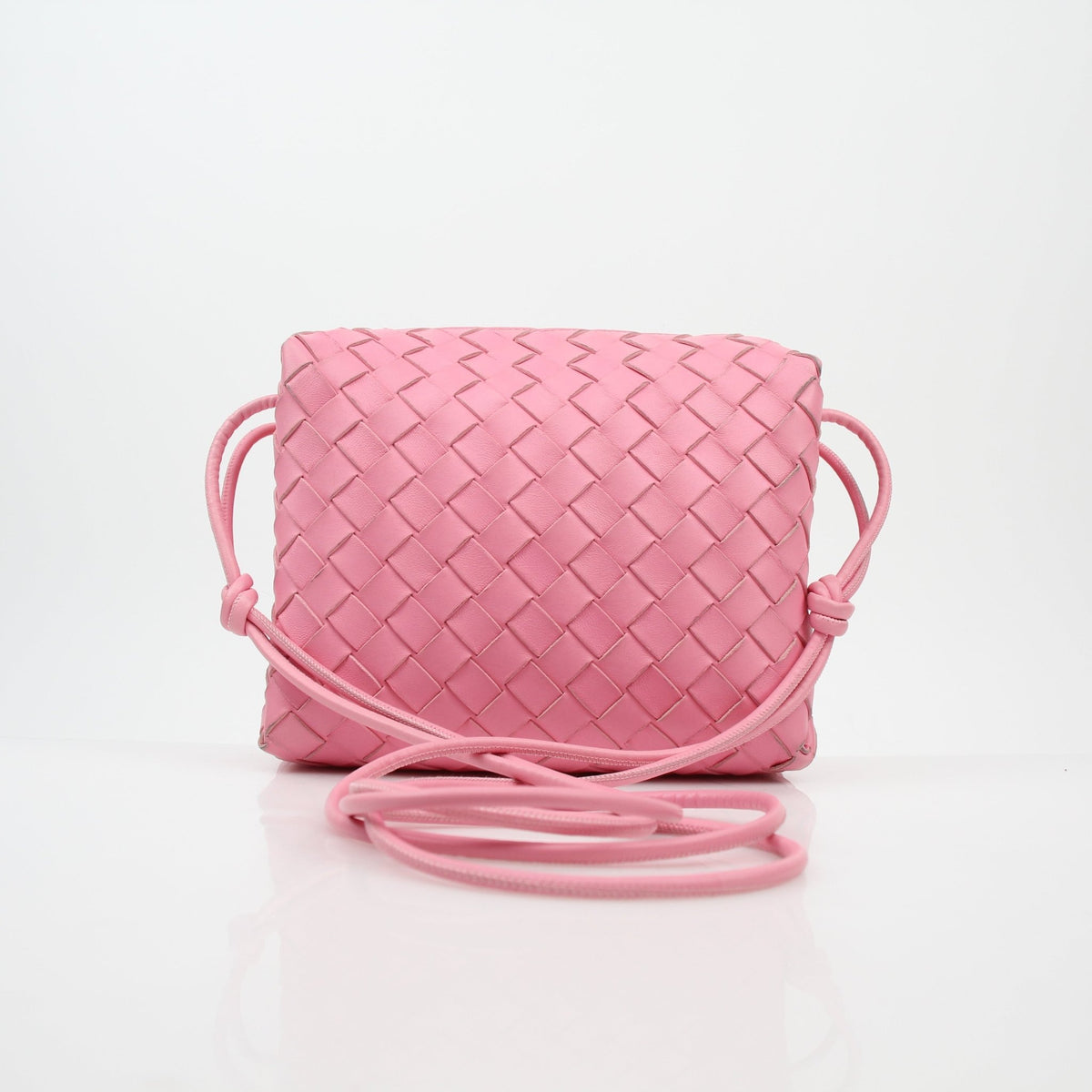 Pink Bottega Veneta Intrecciato Loop Camera Bag handbag with woven leather design and gold accents, stylish and compact.