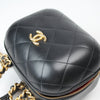 Chanel Matelassé Vanity Shoulder Bag in black leather with gold chain strap and quilted design, displayed on a white surface.