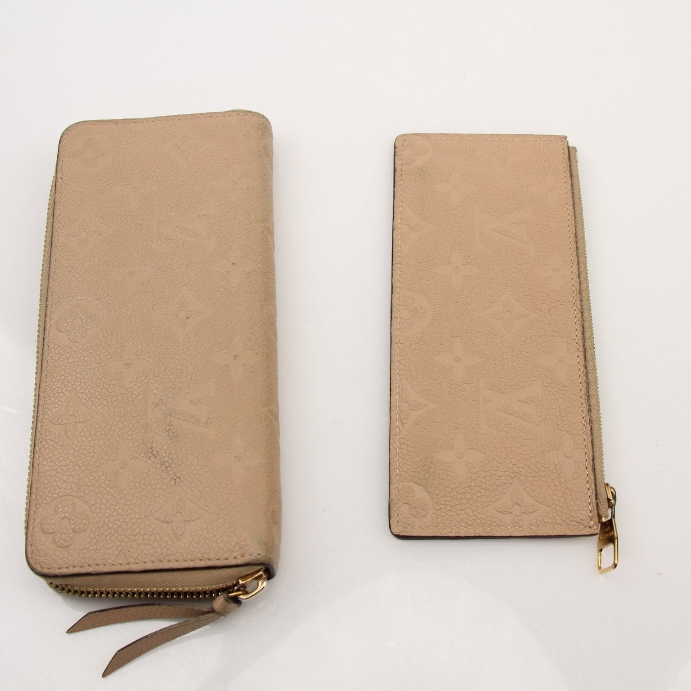 Louis Vuitton Empreinte Clemence wallet with gold-tone hardware and embossed leather, displayed open to show card slots and interior.