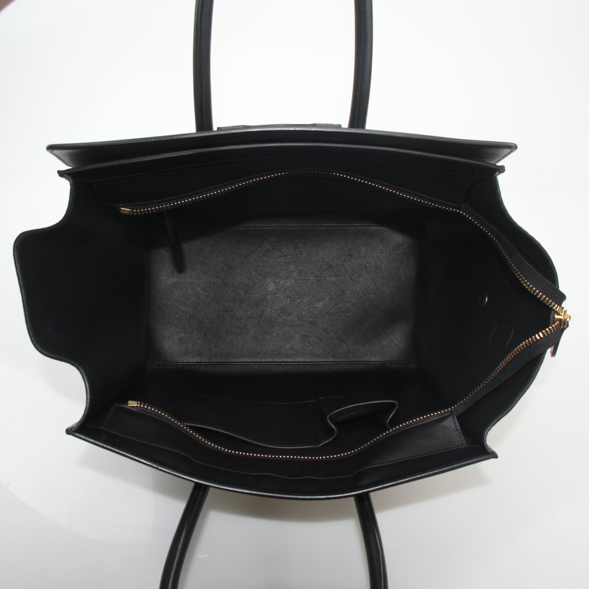 Black Celine luggage tote handbag with gold hardware, spacious design, and structured silhouette by Gold & Beyond.