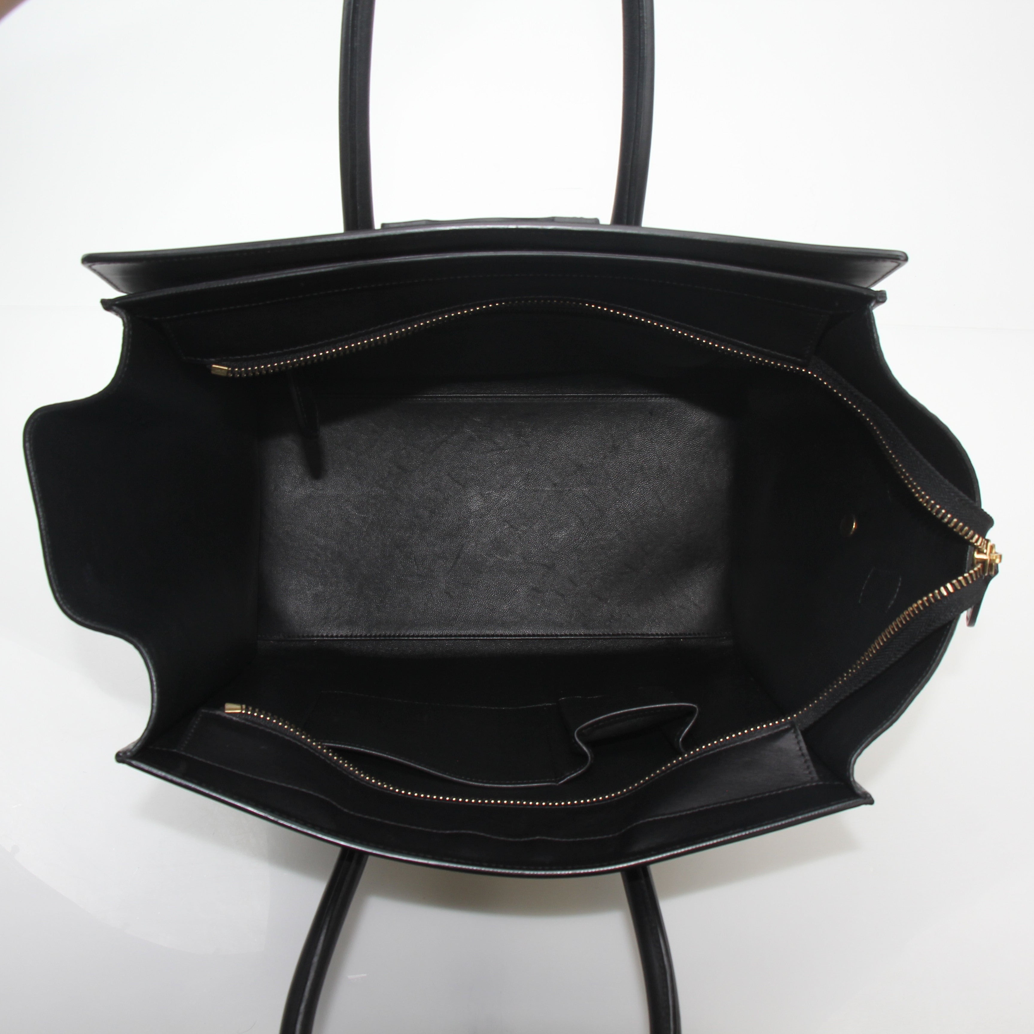Black Celine luggage tote handbag with gold hardware, spacious design, and structured silhouette by Gold & Beyond.