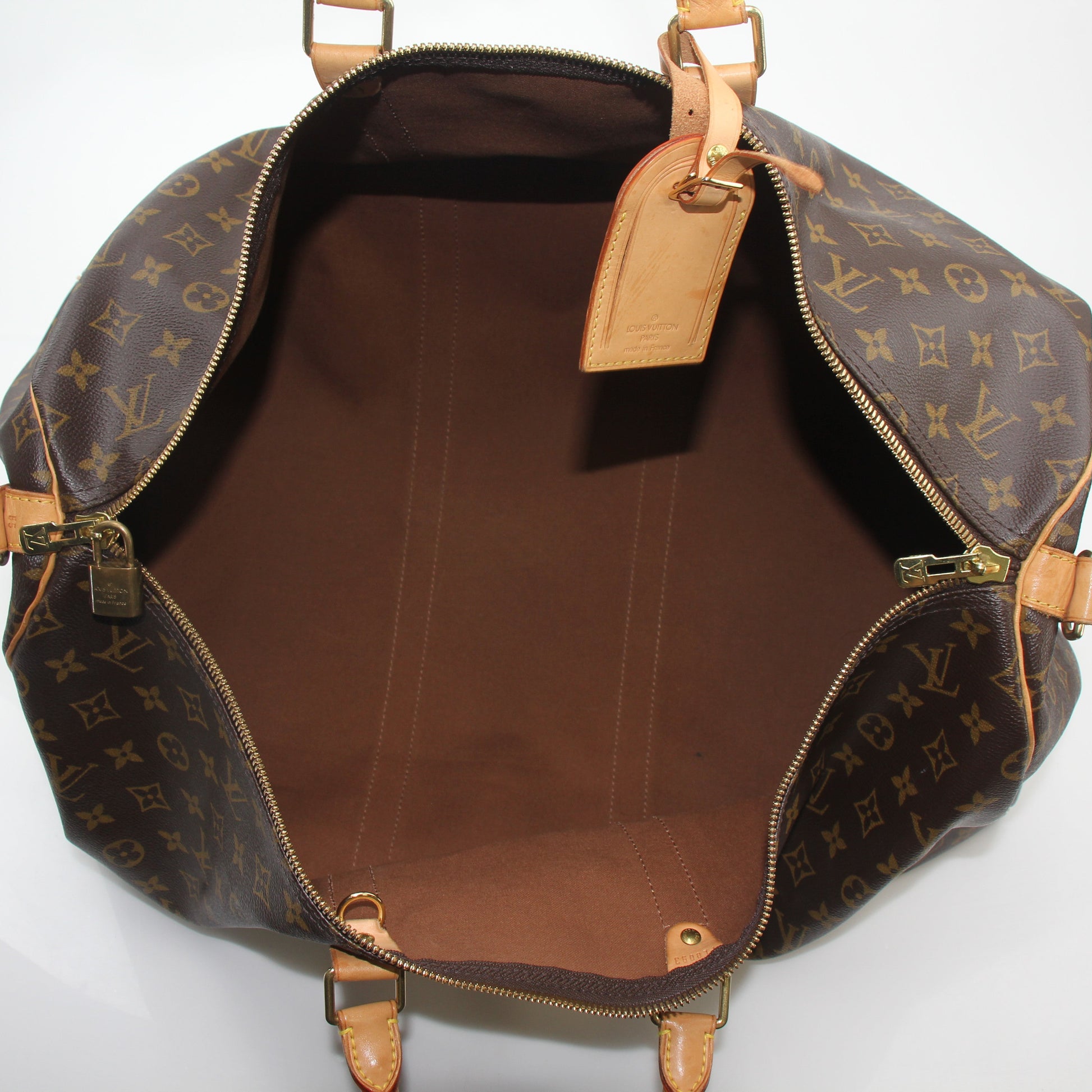 Louis Vuitton Monogram Keepall Bandoulière 55 duffel bag with leather handles and gold-tone hardware, suitable for travel.