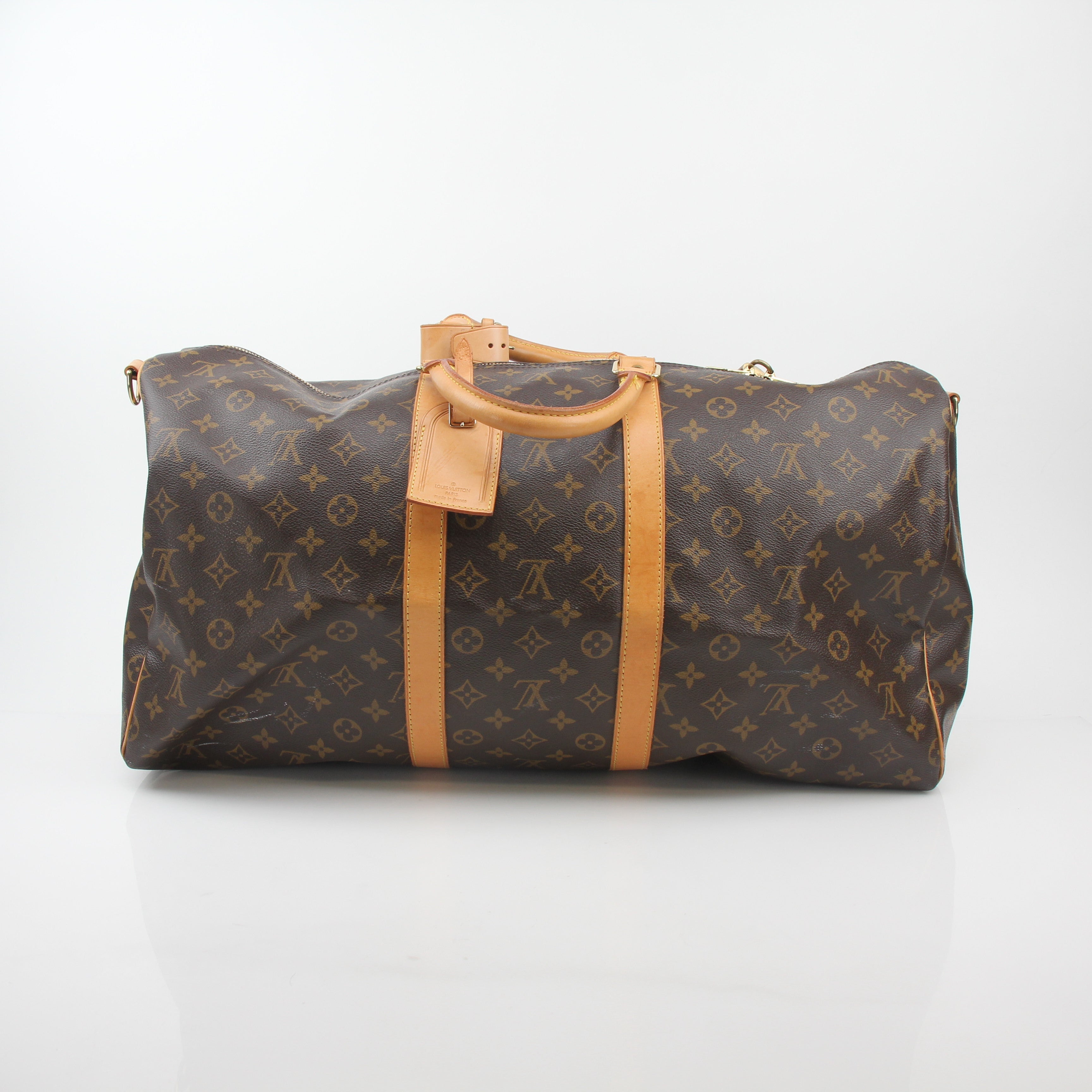 Louis Vuitton Monogram Keepall Bandoulière 55 travel duffel bag with leather handles and gold-tone hardware, featuring iconic monogram pattern.