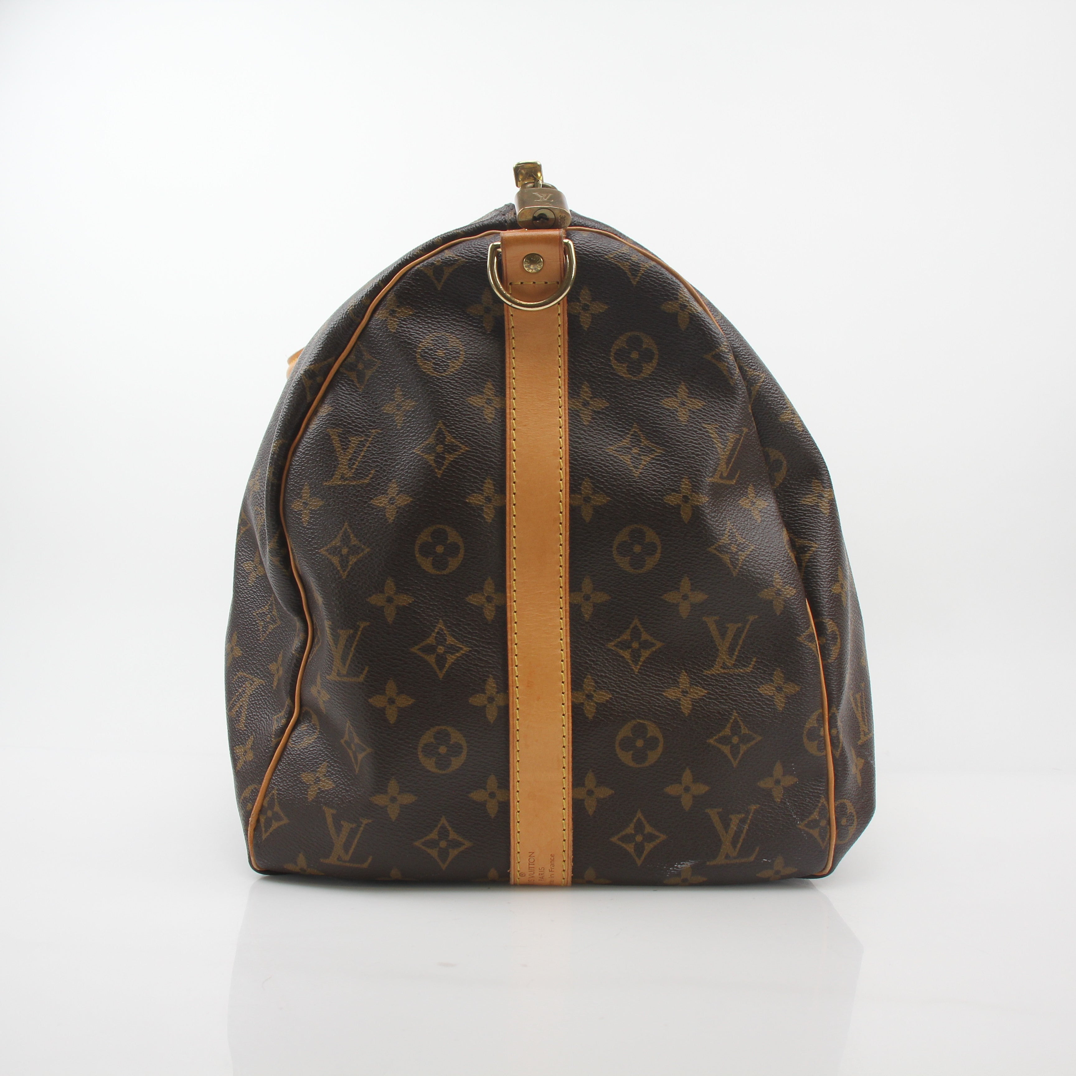 Louis Vuitton Monogram Keepall Bandoulière 55 duffel bag with leather handles and gold hardware, designed for travel and style.