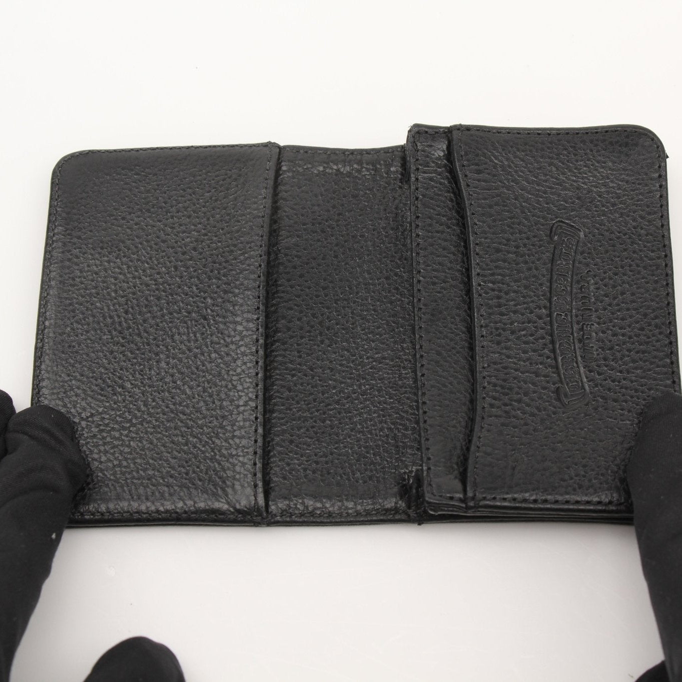 Chrome Hearts leather card wallet with silver hardware and branded logo, featuring multiple card slots and a sleek design.