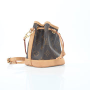 Louis Vuitton Monogram Nano Noé bucket handbag with leather drawstring and gold-tone hardware, shown in a close-up view.