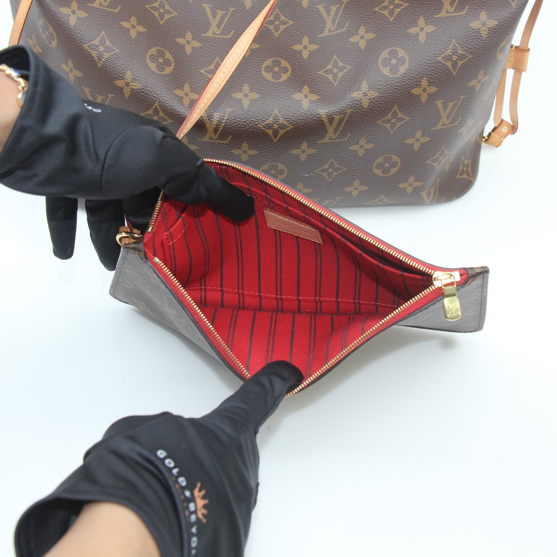 Louis Vuitton Monogram Neverfull MM tote handbag with leather handles and spacious interior, displayed on a neutral background.