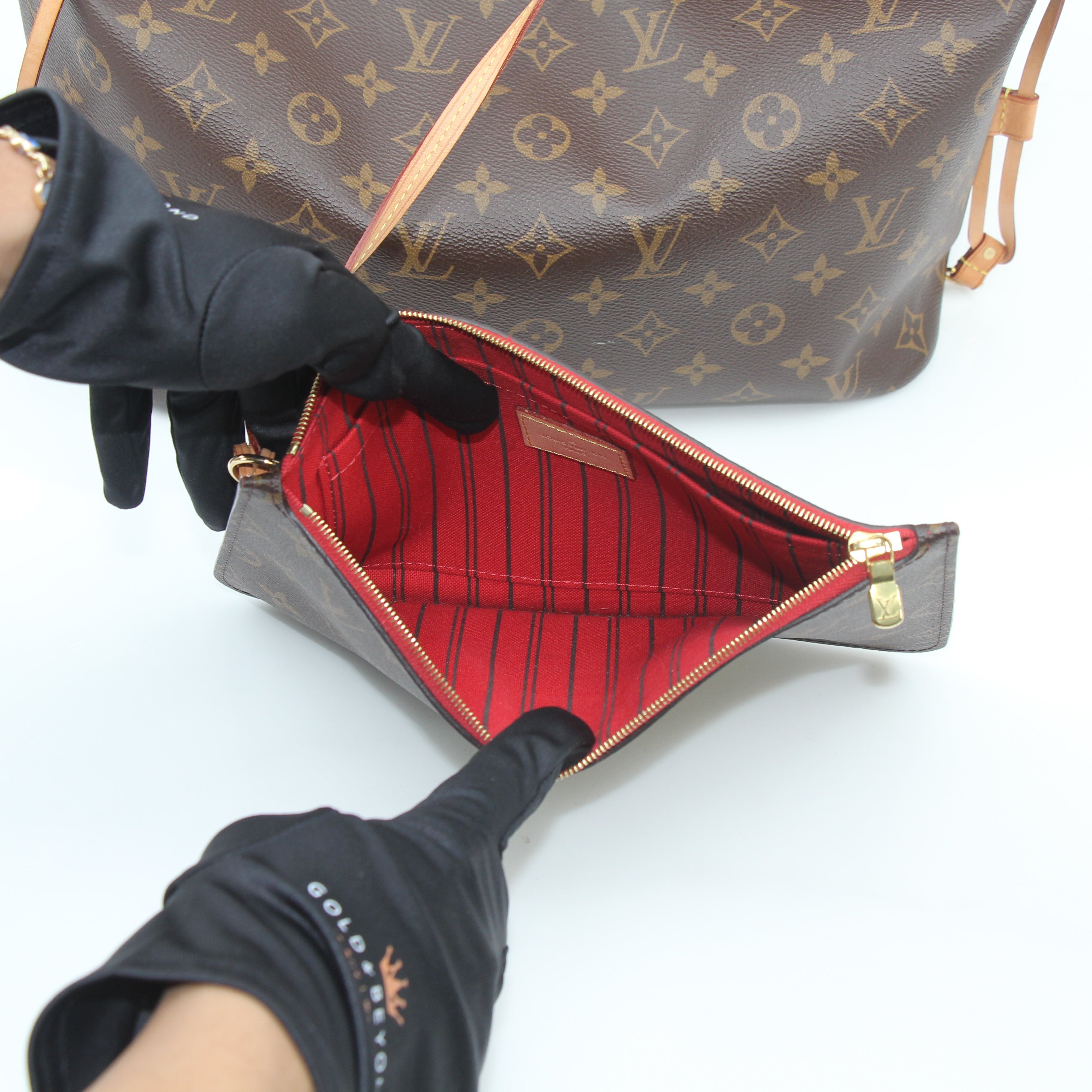 Louis Vuitton Monogram Neverfull MM tote handbag with leather handles and spacious interior, displayed on a neutral background.