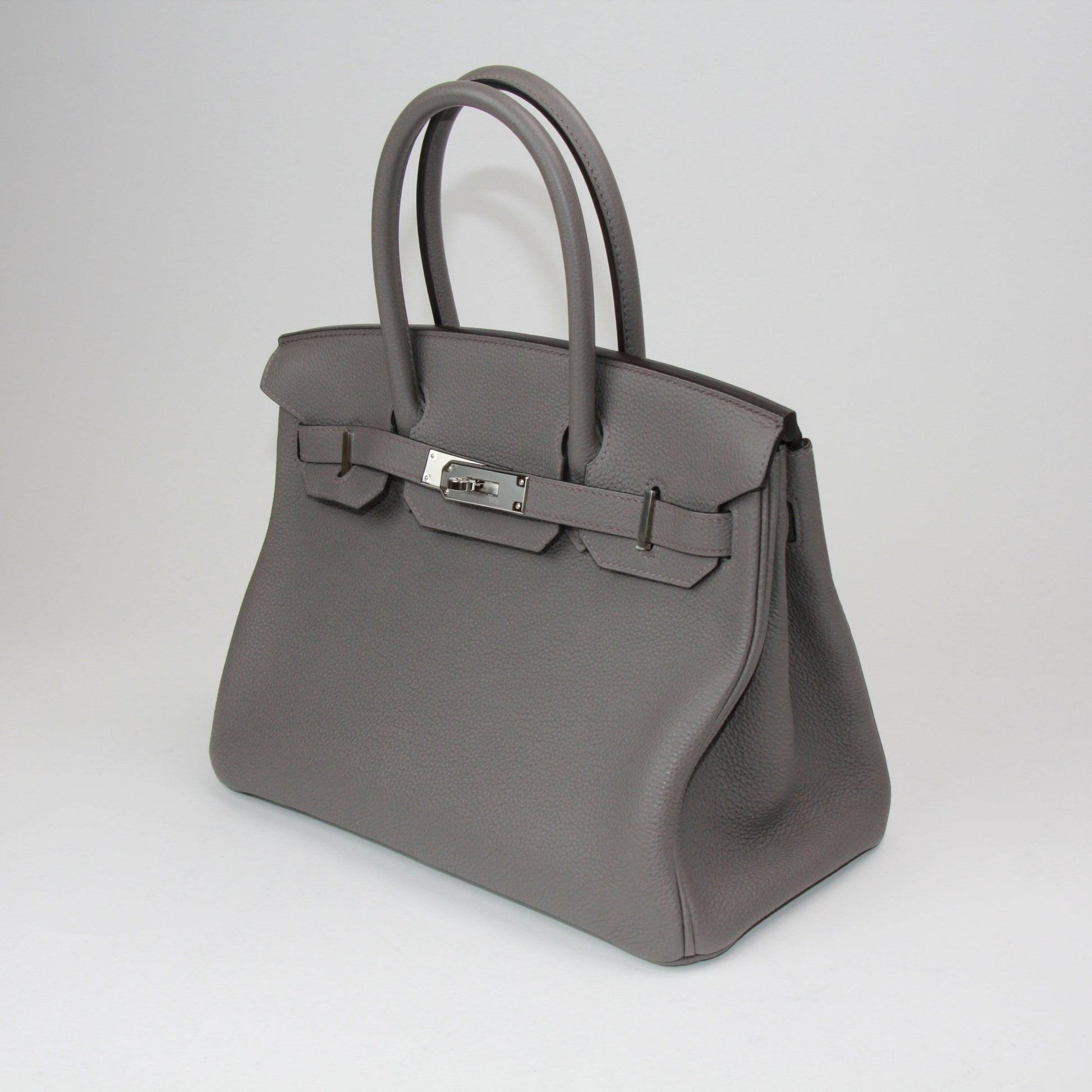Hermès Birkin 30 handbag in luxurious leather with gold hardware, featuring double handles and a spacious interior.