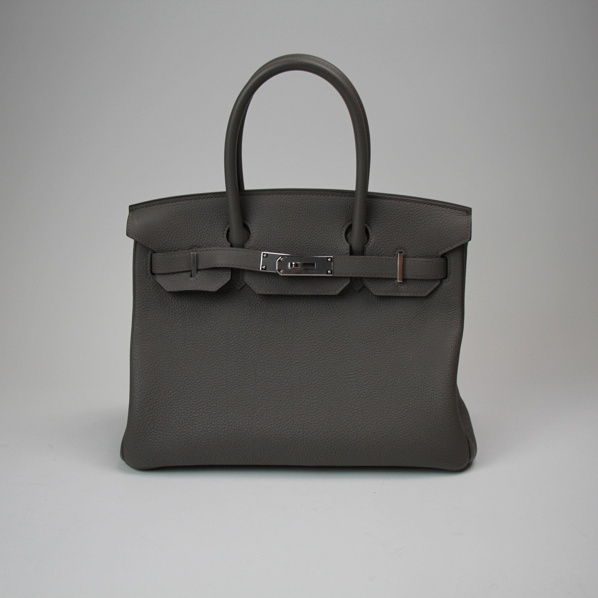 Hermès Birkin 30 handbag in luxurious leather, featuring gold hardware and classic design, displayed in a stylish setting.