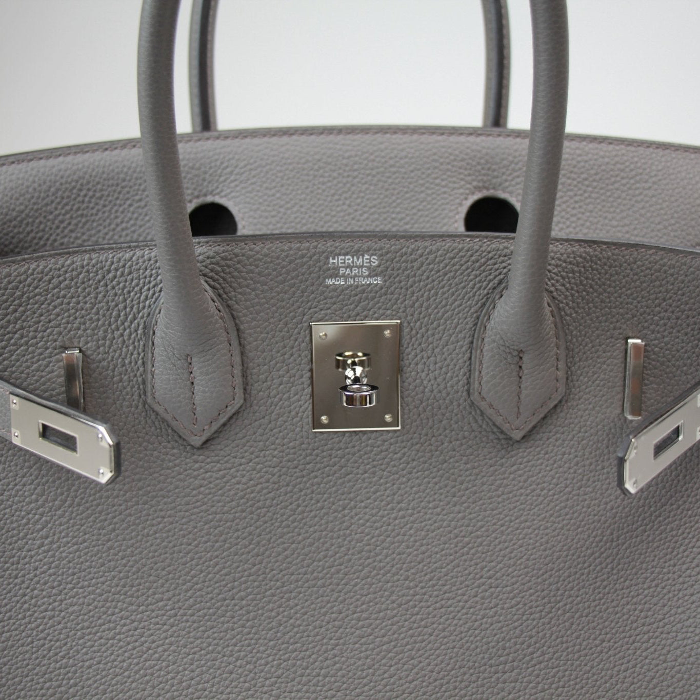 Hermès Birkin 30 handbag in luxurious leather with gold hardware, displayed on a neutral background.