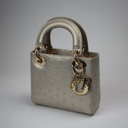 Gold & Beyond mini Lady Dior handbag with beige canvas and leather accents, featuring signature Dior quilting and top handles.