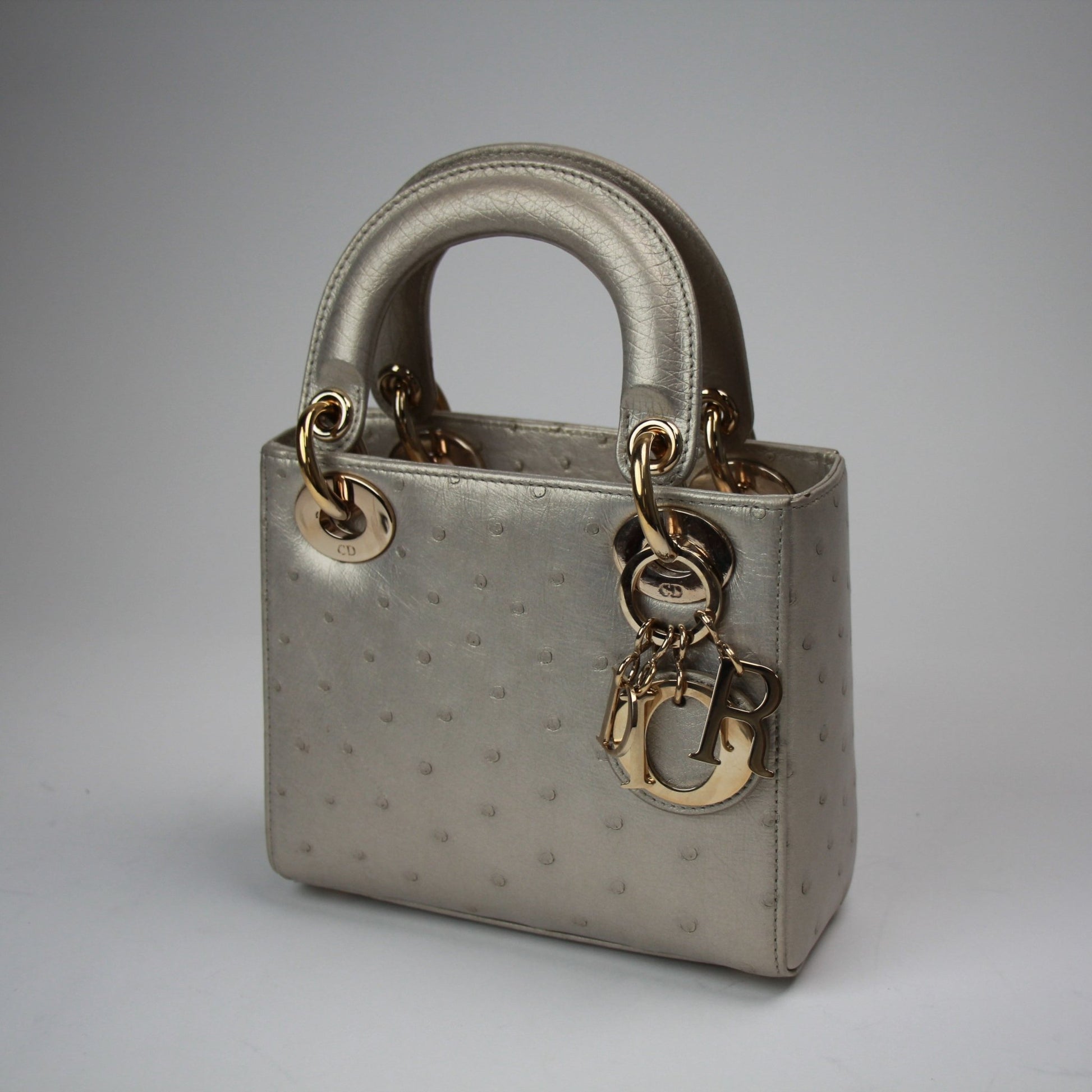 Gold & Beyond mini Lady Dior handbag with beige canvas and leather accents, featuring signature Dior quilting and top handles.