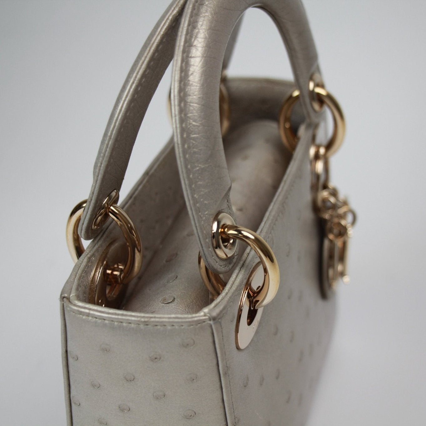 Gold & Beyond mini Lady Dior handbag, elegant beige leather handbag with signature Dior charms and top handle.