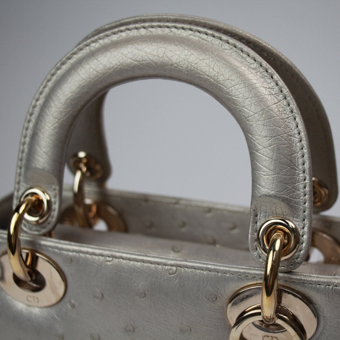 Gold & Beyond Dior Lady Dior Mini Bag handbag with quilted design and top handles, stylish accessory for elegant occasions.
