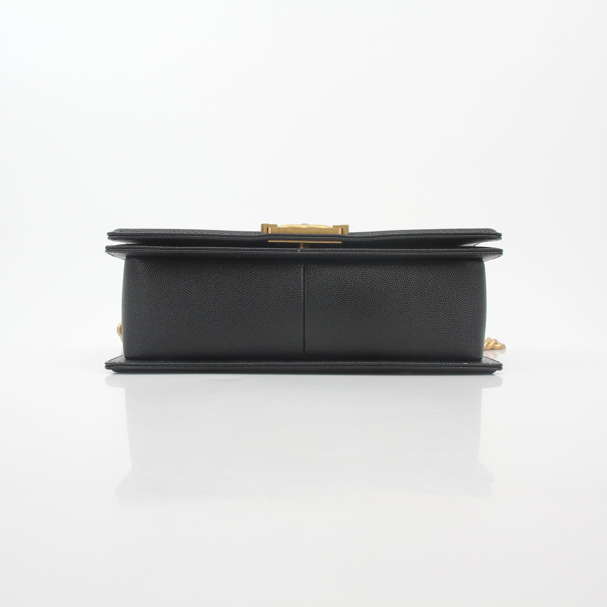 Chanel black caviar leather Boy flap shoulder handbag with gold hardware, featuring signature quilting and chain strap detail.