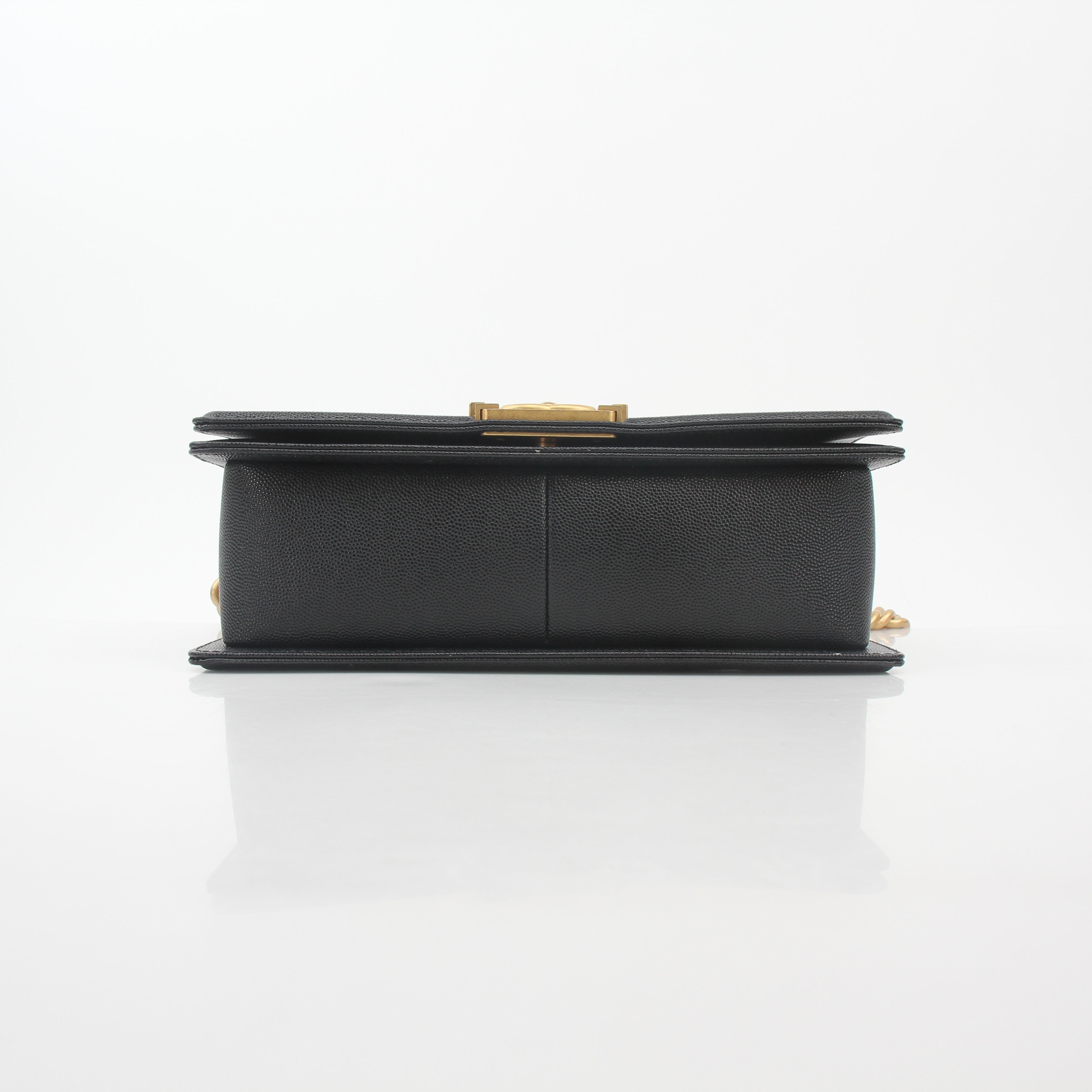 Chanel black caviar leather Boy flap shoulder handbag with gold hardware, featuring signature quilting and chain strap detail.