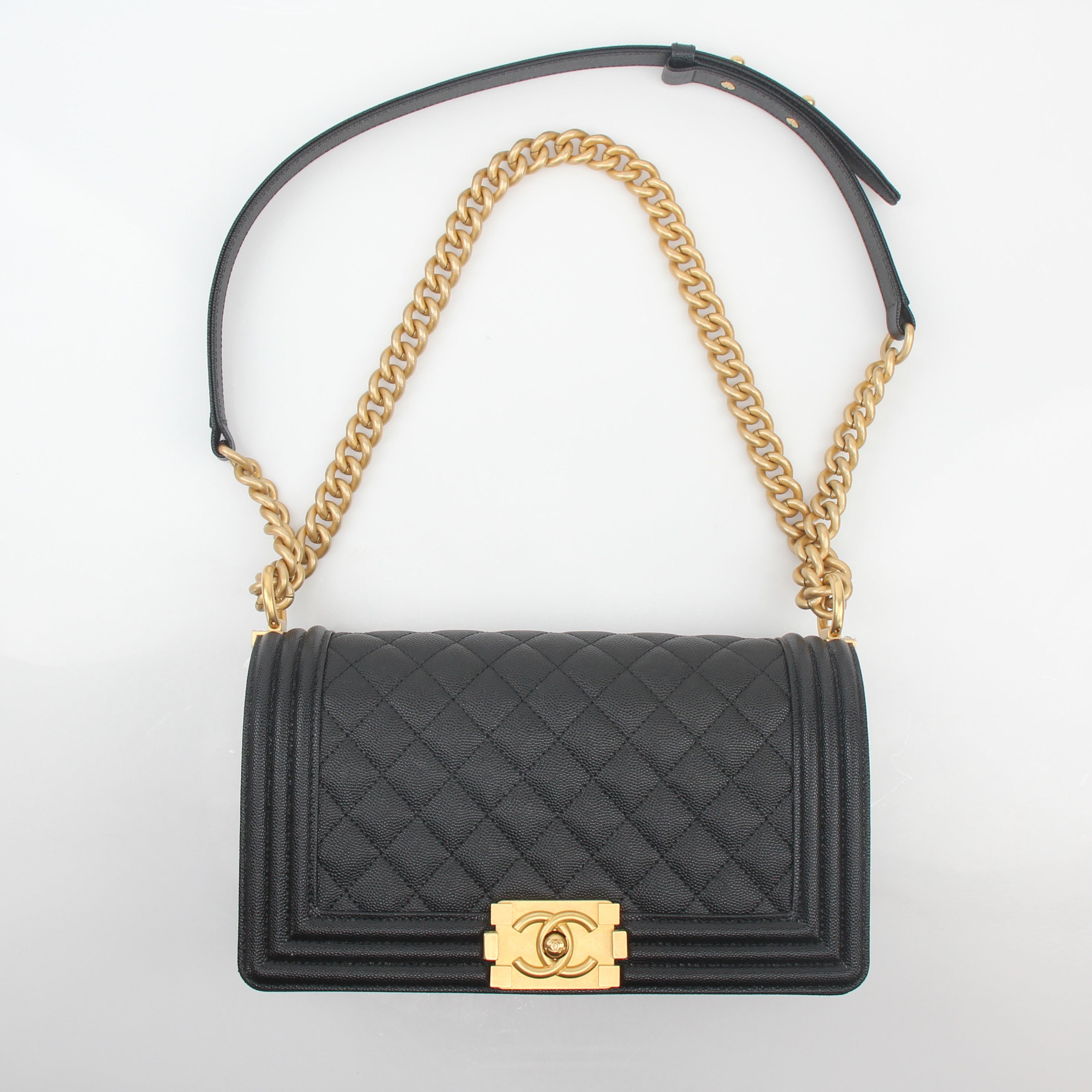 Chanel Black Caviar Boy Flap Shoulder Bag with gold hardware, featuring quilted leather and a chain strap, on a plain background.