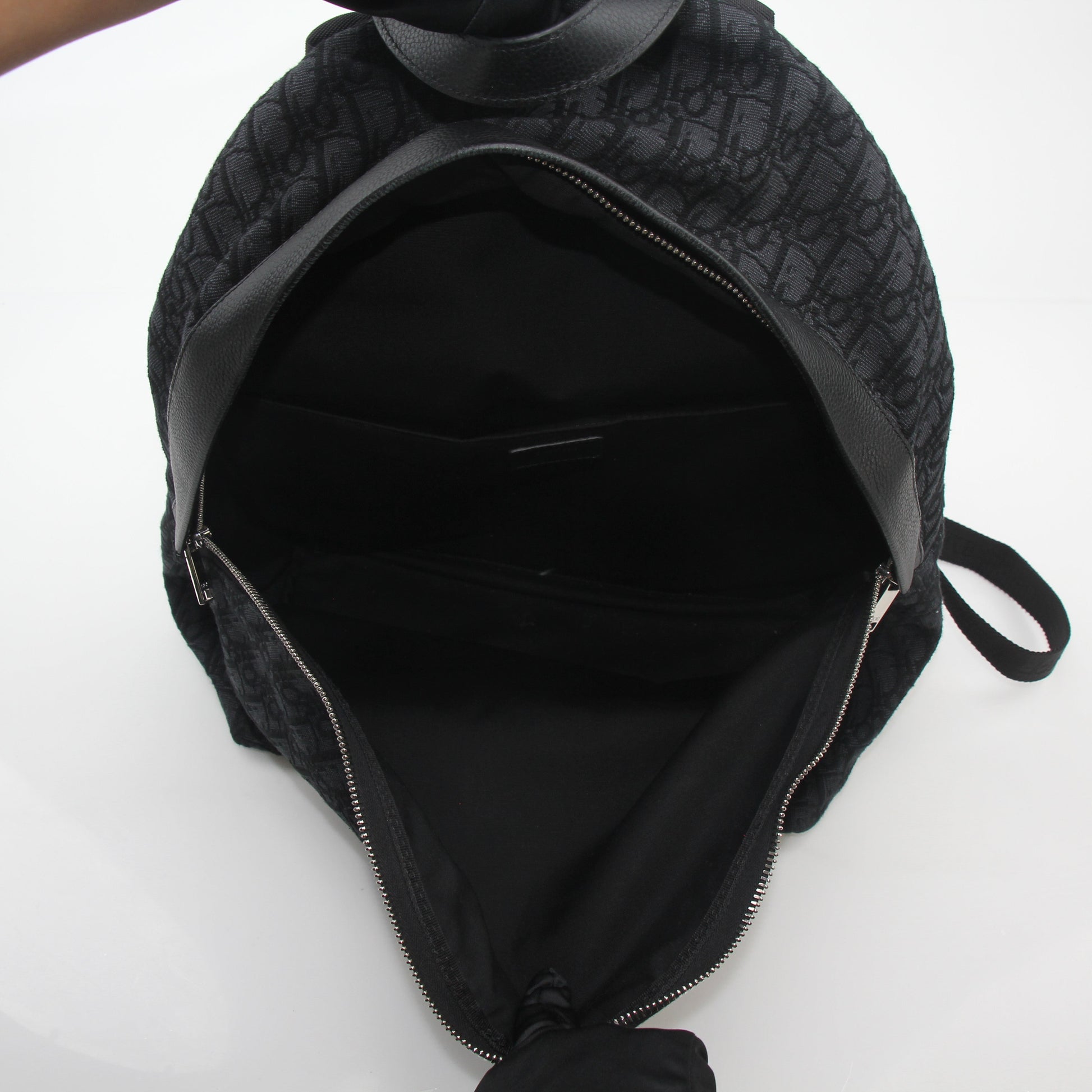 Black Dior Oblique Rider Backpack by Christian Dior, a stylish travel bag with adjustable straps and signature pattern.