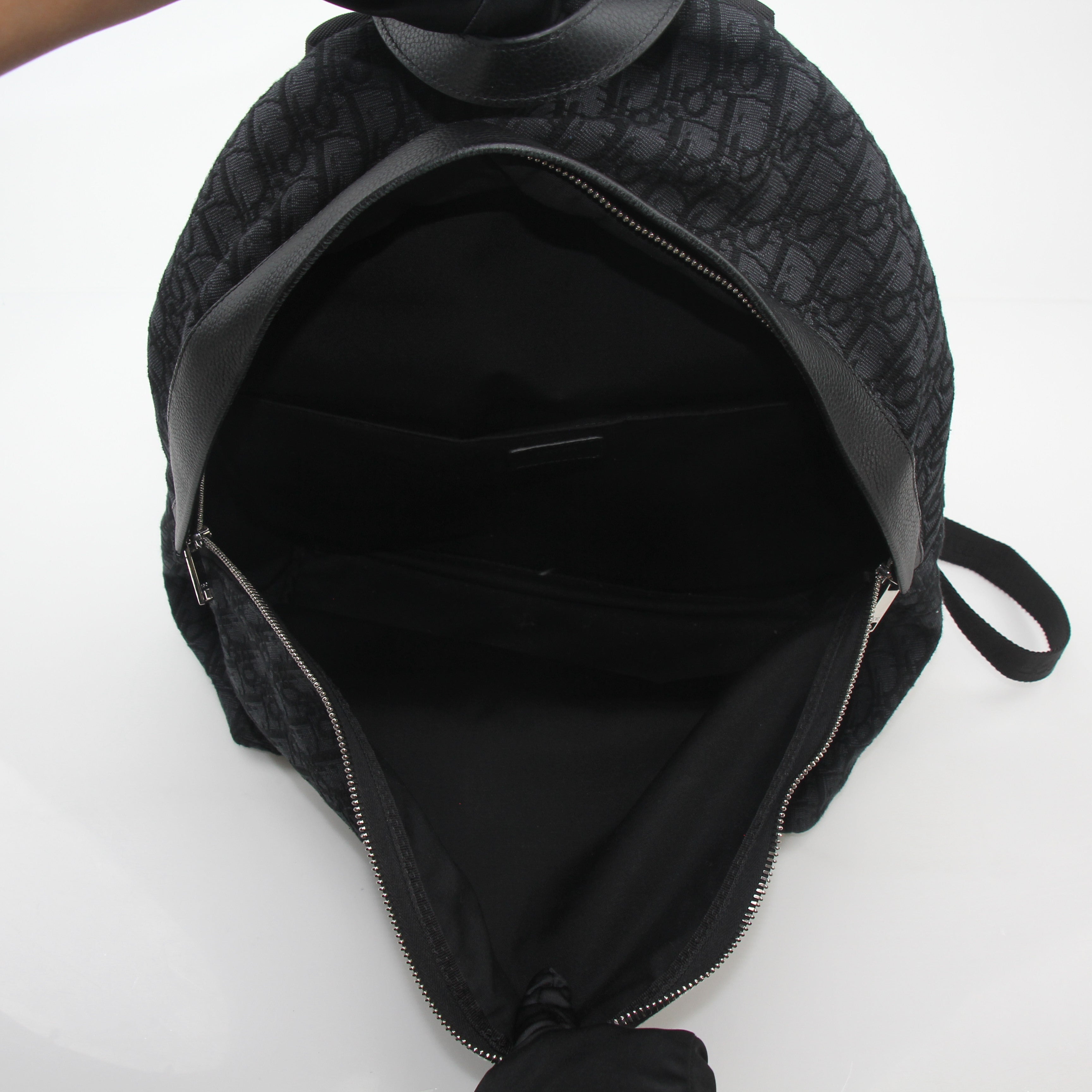 Black Dior Oblique Rider Backpack by Christian Dior, a stylish travel bag with adjustable straps and signature pattern.