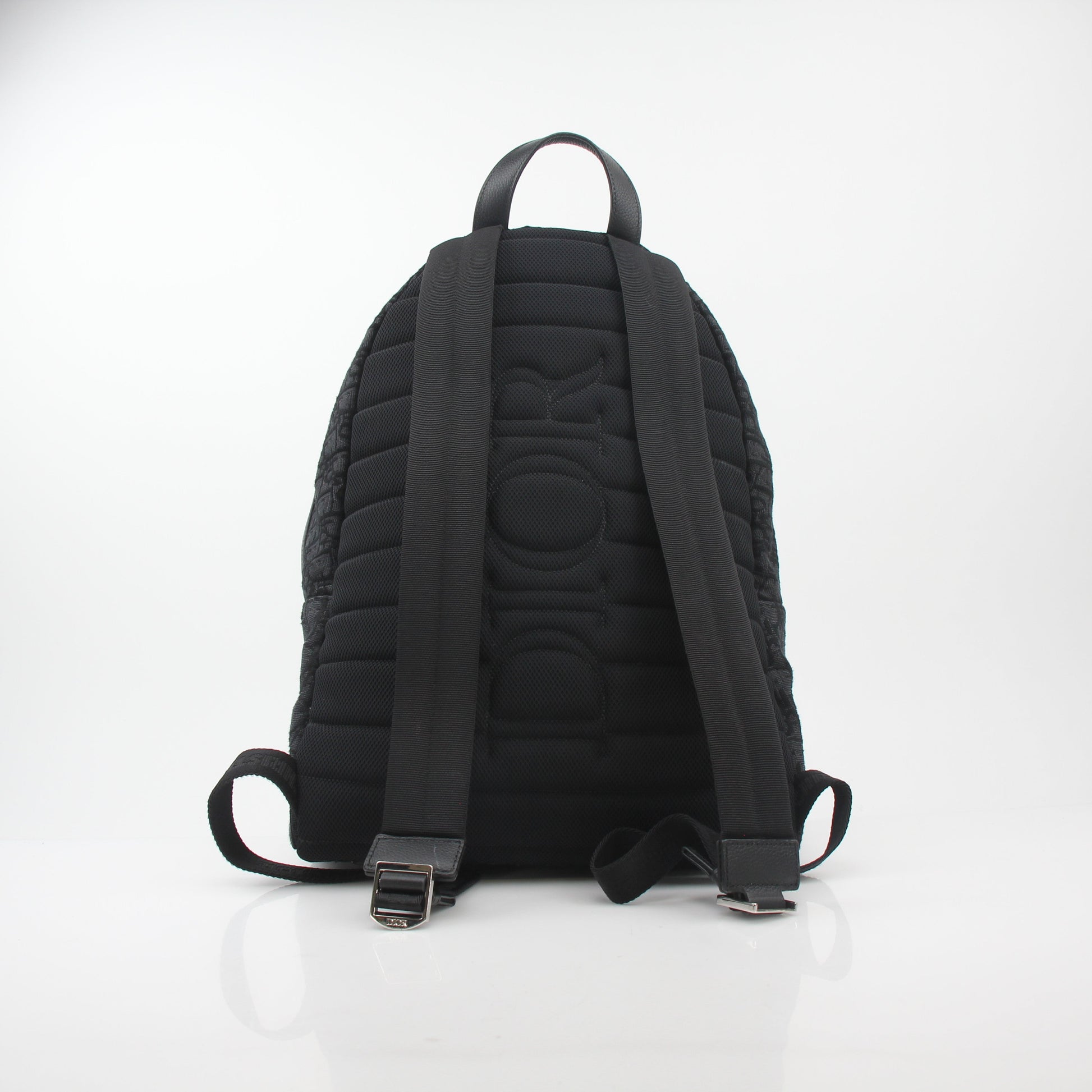 Black Christian Dior Dior Oblique Rider backpack with gold hardware, featuring adjustable straps and a spacious interior, designed for travel.
