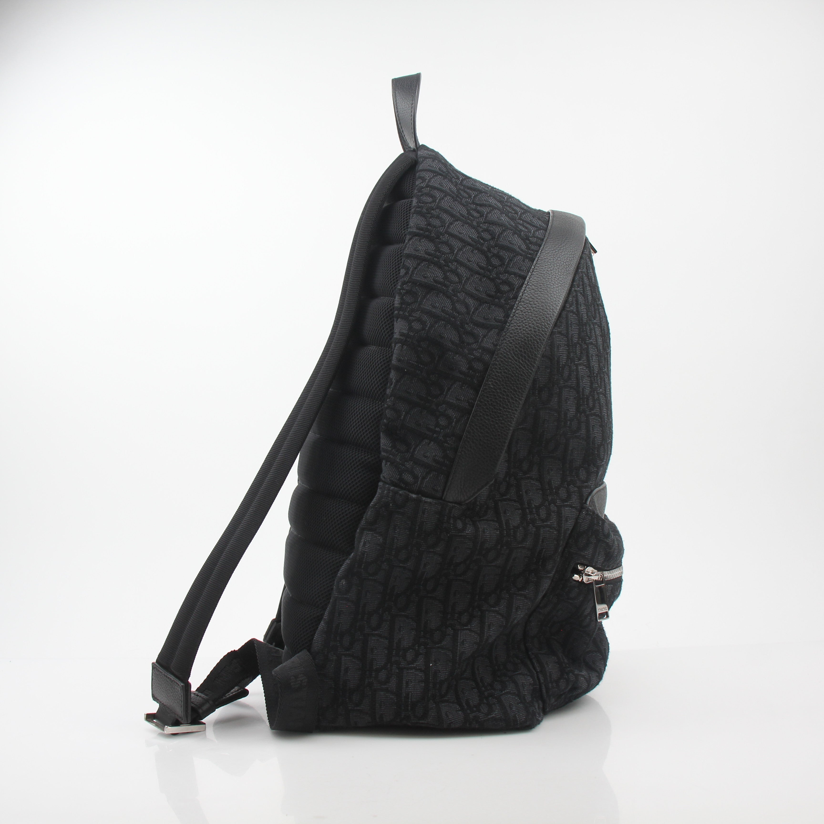 Black Christian Dior Dior Oblique Rider Backpack for travel, featuring signature pattern and sturdy leather straps.