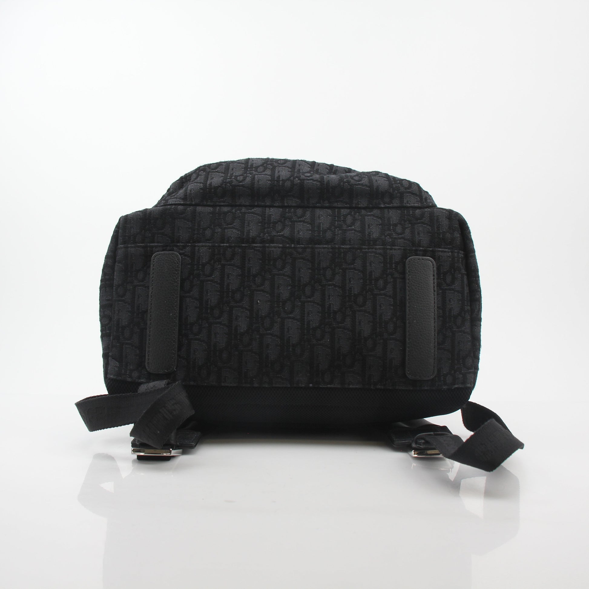Black Dior Oblique Rider Backpack by Christian Dior, featuring sleek travel bag design with gold accents and adjustable straps.
