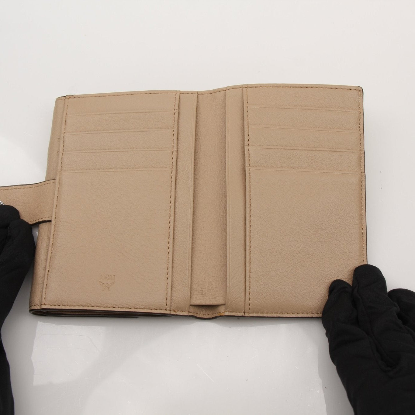 Gold & Beyond MCM trifold beige wallet with multiple card slots and a sleek leather finish.