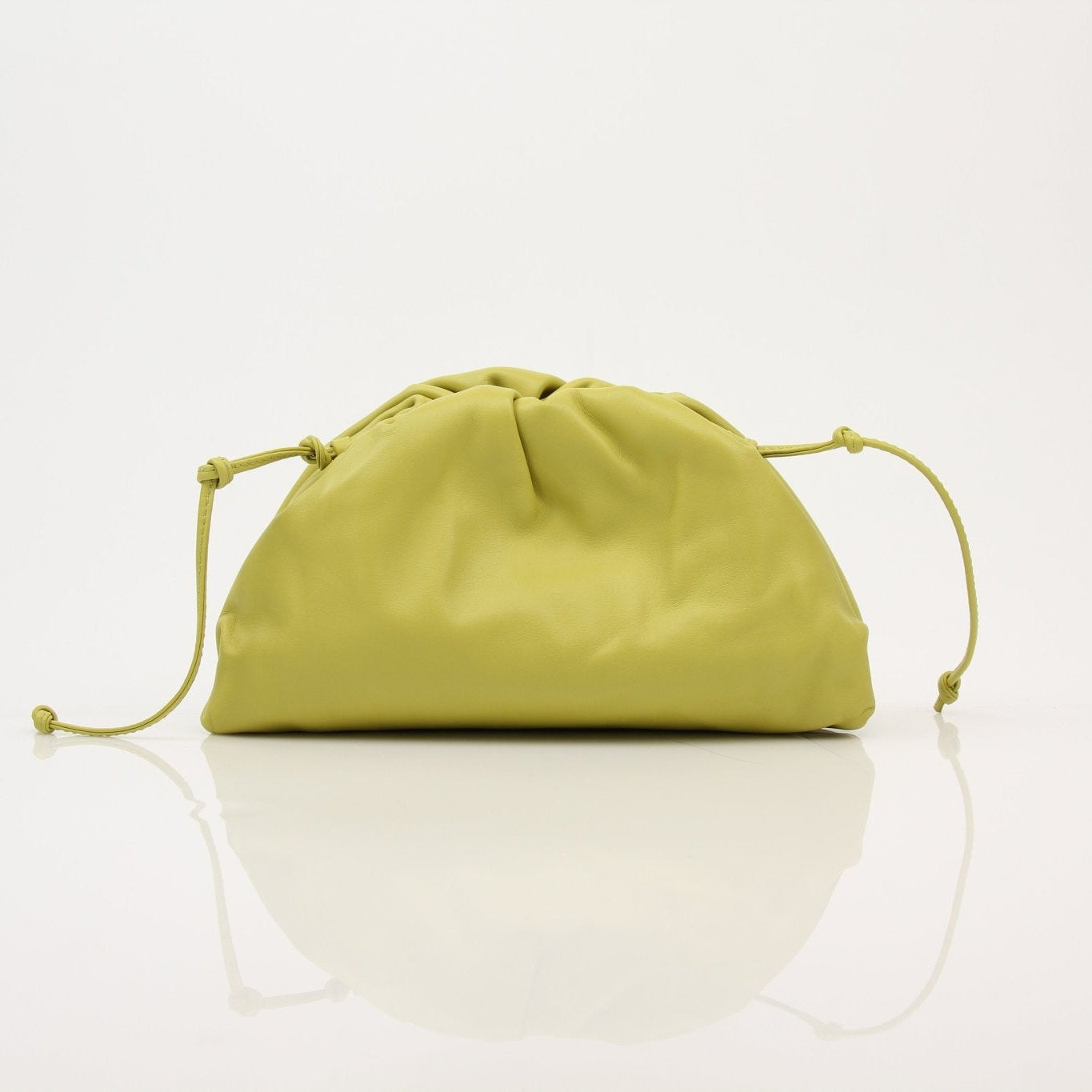 Green Bottega Veneta The Pouch Mini handbag with gold accents, stylishly displayed on a neutral background.