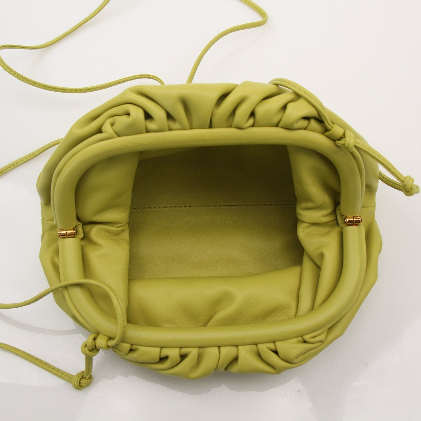 Green Bottega Veneta The Pouch Mini handbag with gold hardware, featuring a sleek, compact design and soft leather finish.