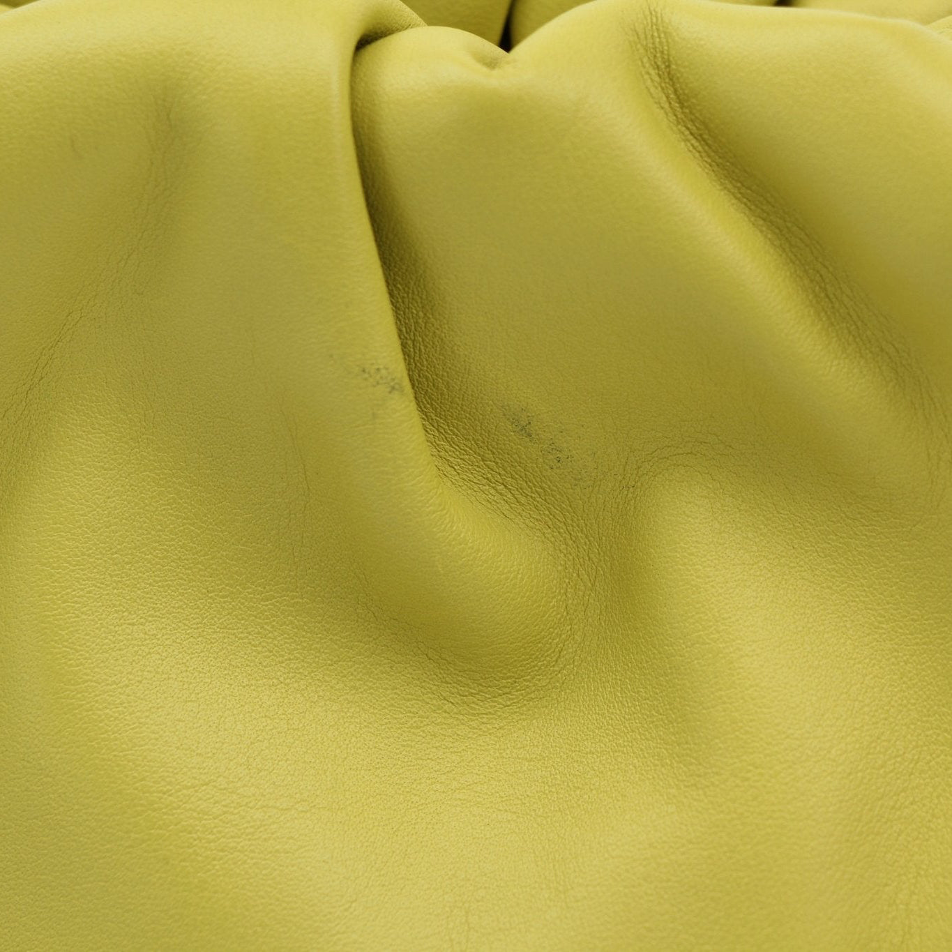 Green Bottega Veneta The Pouch Mini handbag with gold accents, showcasing its sleek, textured leather design.