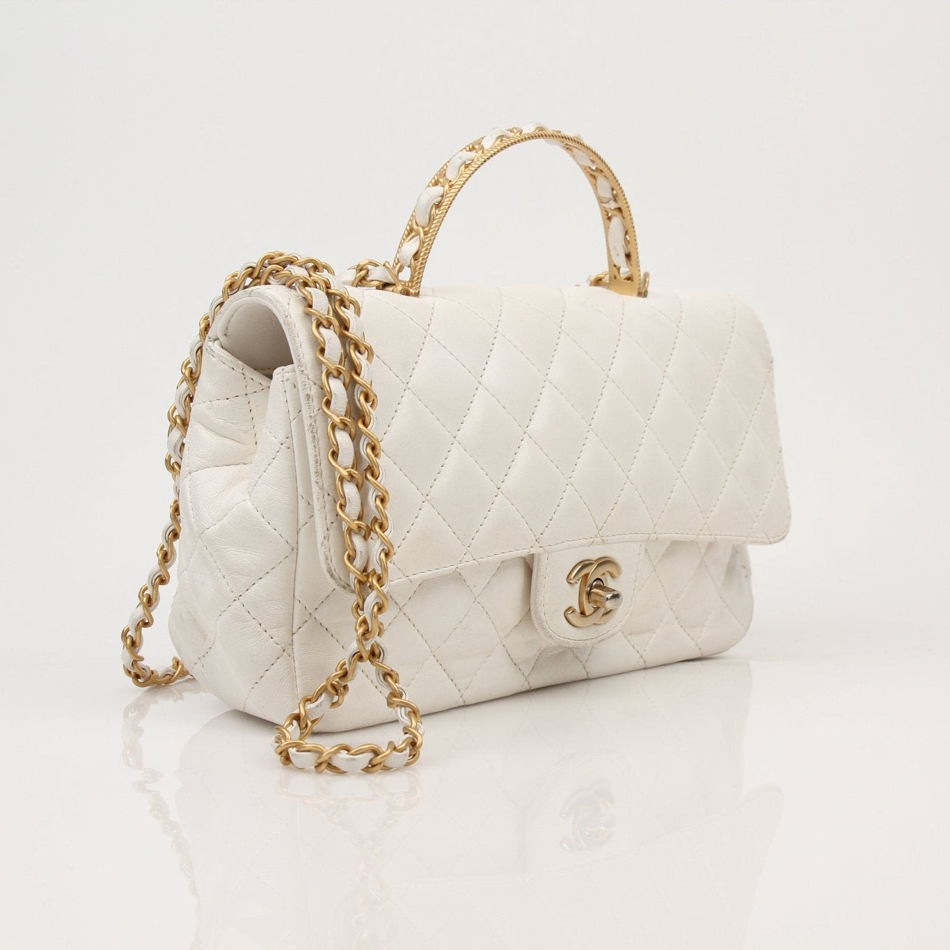 Gold & Beyond Chanel lambskin top handle handbag with gold hardware, featuring a classic design and elegant top handle.