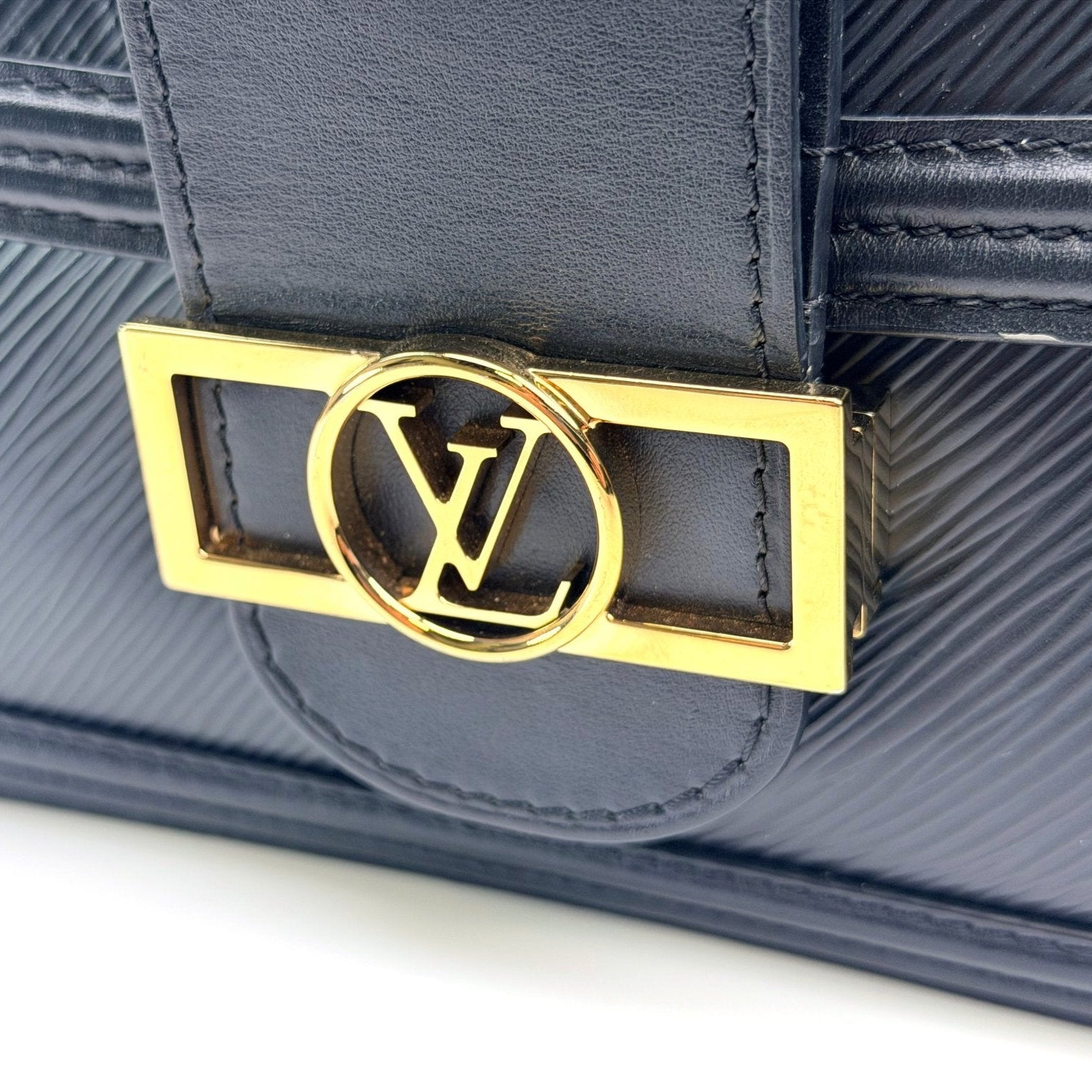 Gold & Beyond Louis Vuitton Mini Dauphine crossbody handbag with monogram canvas and leather strap on a plain background.