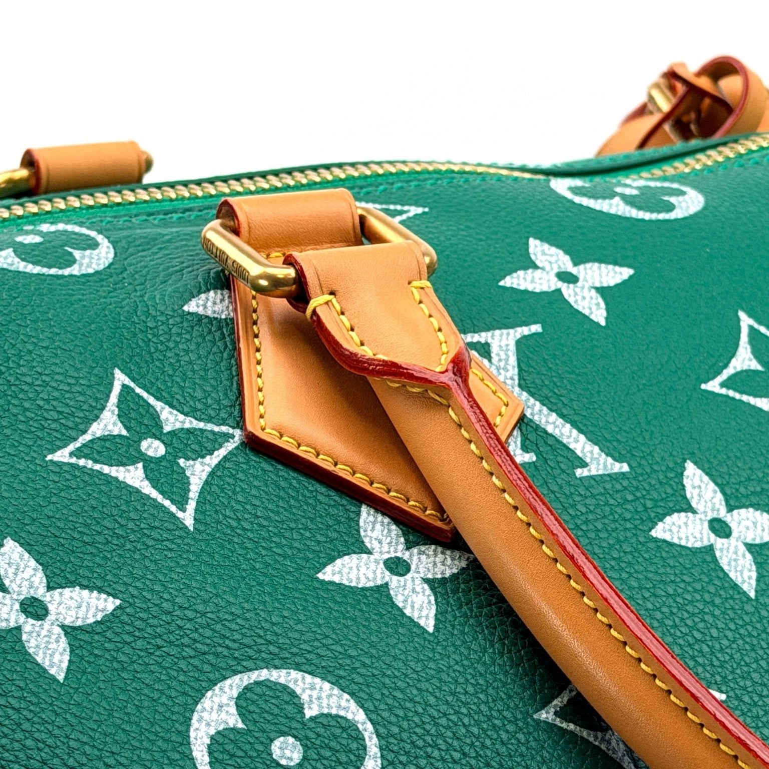 Gold & Beyond Louis Vuitton Speedy 950 travel bag with leather handles and classic monogram canvas, detailed view of the bag's exterior.