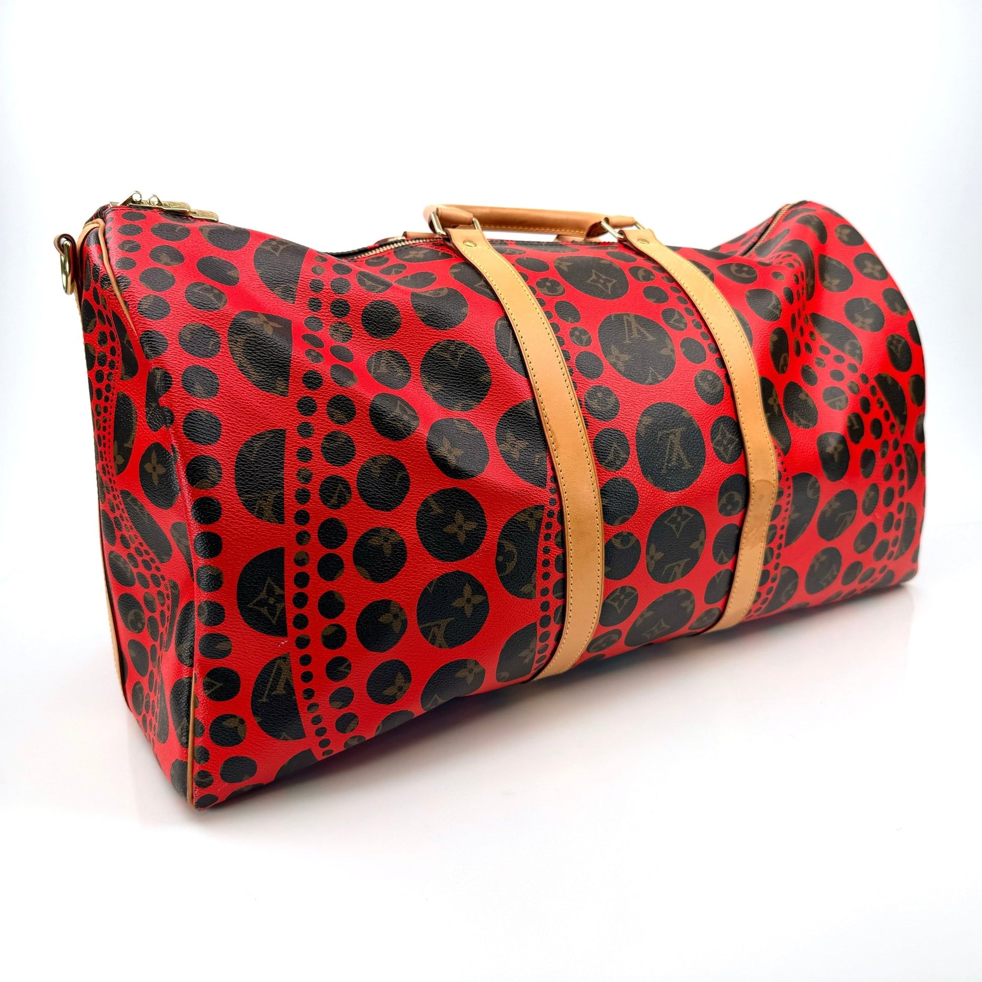 Louis Vuitton x Yayoi Kusama polka dot travel bag by Gold & Beyond, featuring vibrant red and black dotted design with sturdy handles.